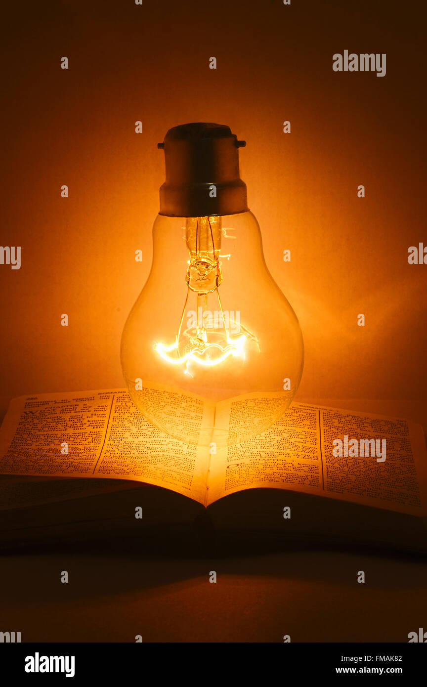 Offenes Buch Bibel mit Glühlampe darüber Stockfoto