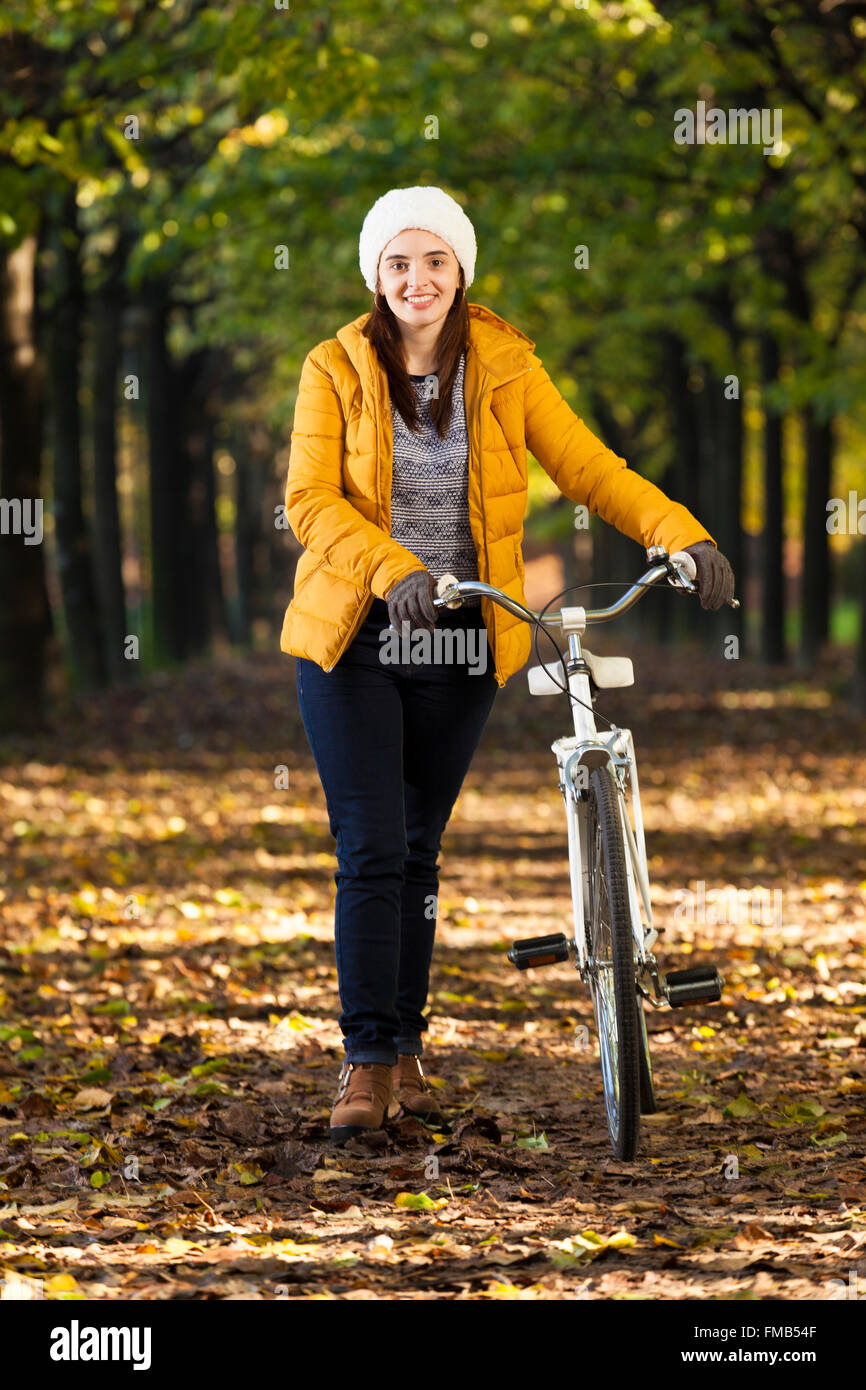 Lächelnde Frau mit einem Oldtimer Fahrrad im park Stockfoto