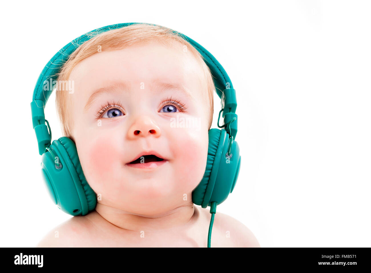 Smiling Baby mit Kopfhörern Musik hören, isoliert auf weißem Hintergrund Stockfoto
