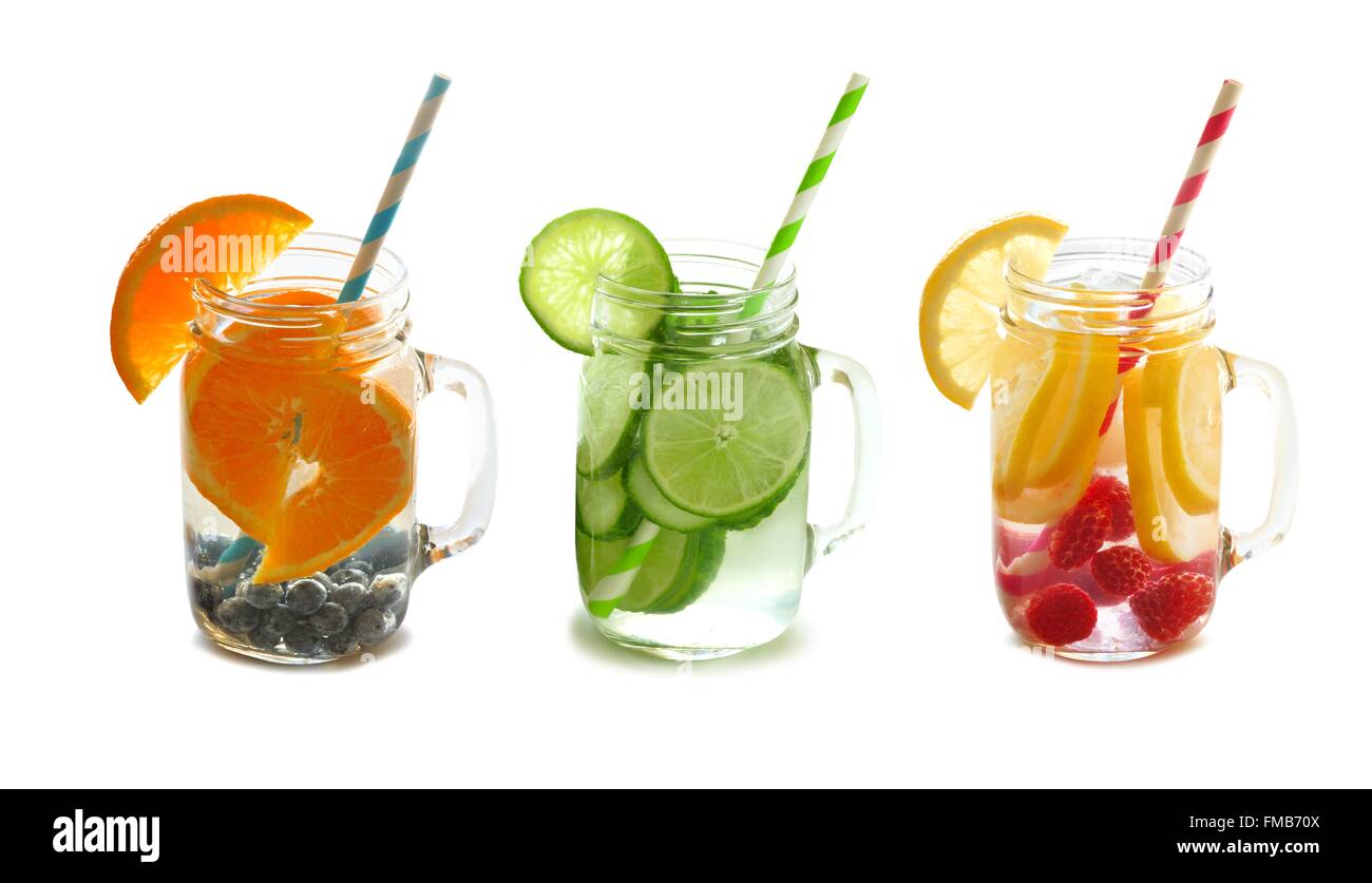 Drei Arten von Obst gefüllt Detox Wasser in Einweckgläser mit Stroh isoliert auf weißem Hintergrund Stockfoto