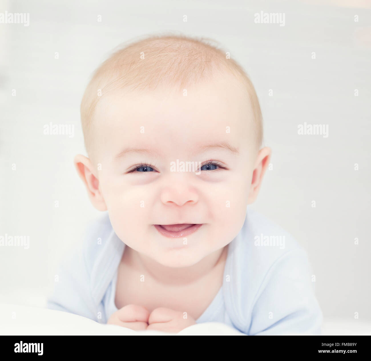 Baby mit blauen Augen auf die Kamera und lächelnd Stockfoto