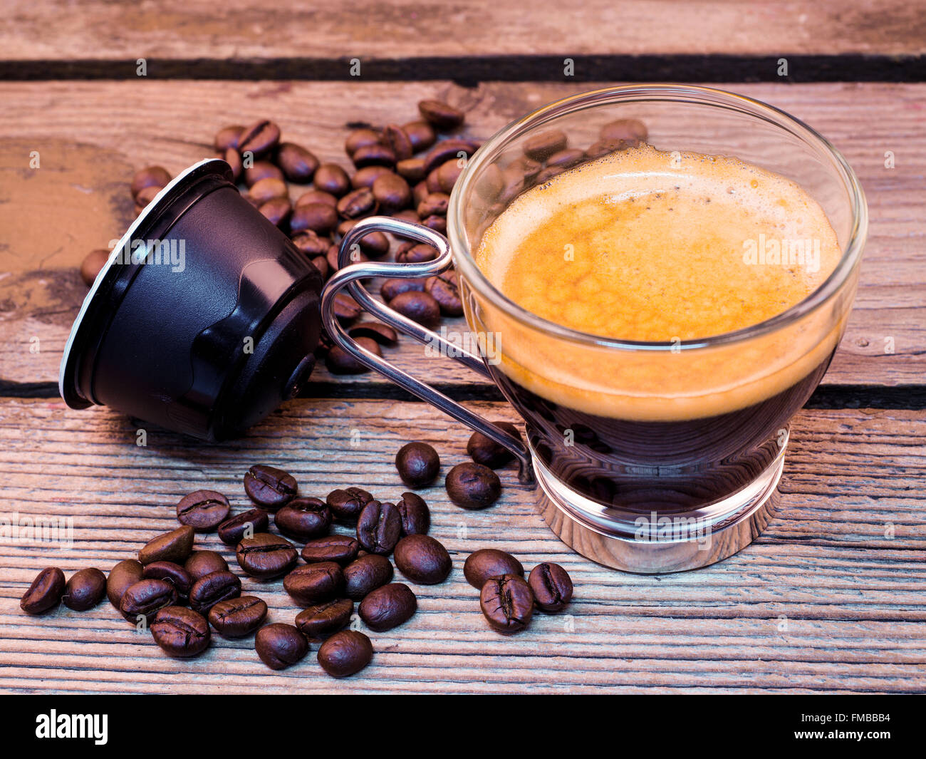 Tasse Kaffee und Hülsen auf Holztisch Stockfoto