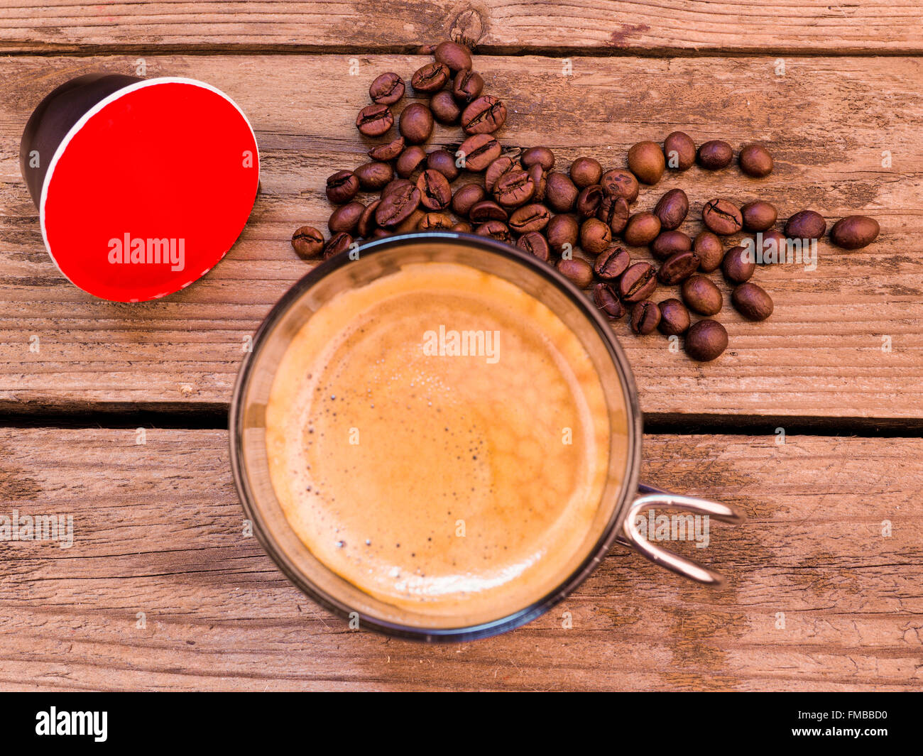 Tasse Kaffee und Hülsen auf Holztisch Stockfoto