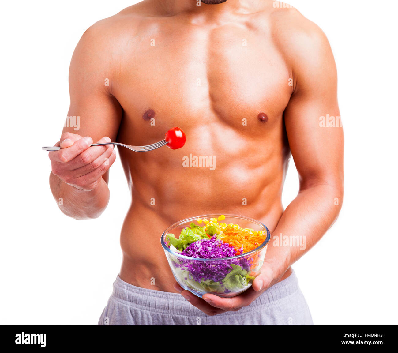 Passen Sie Mann hält eine Schale mit frischem Salat auf weißem Hintergrund Stockfoto
