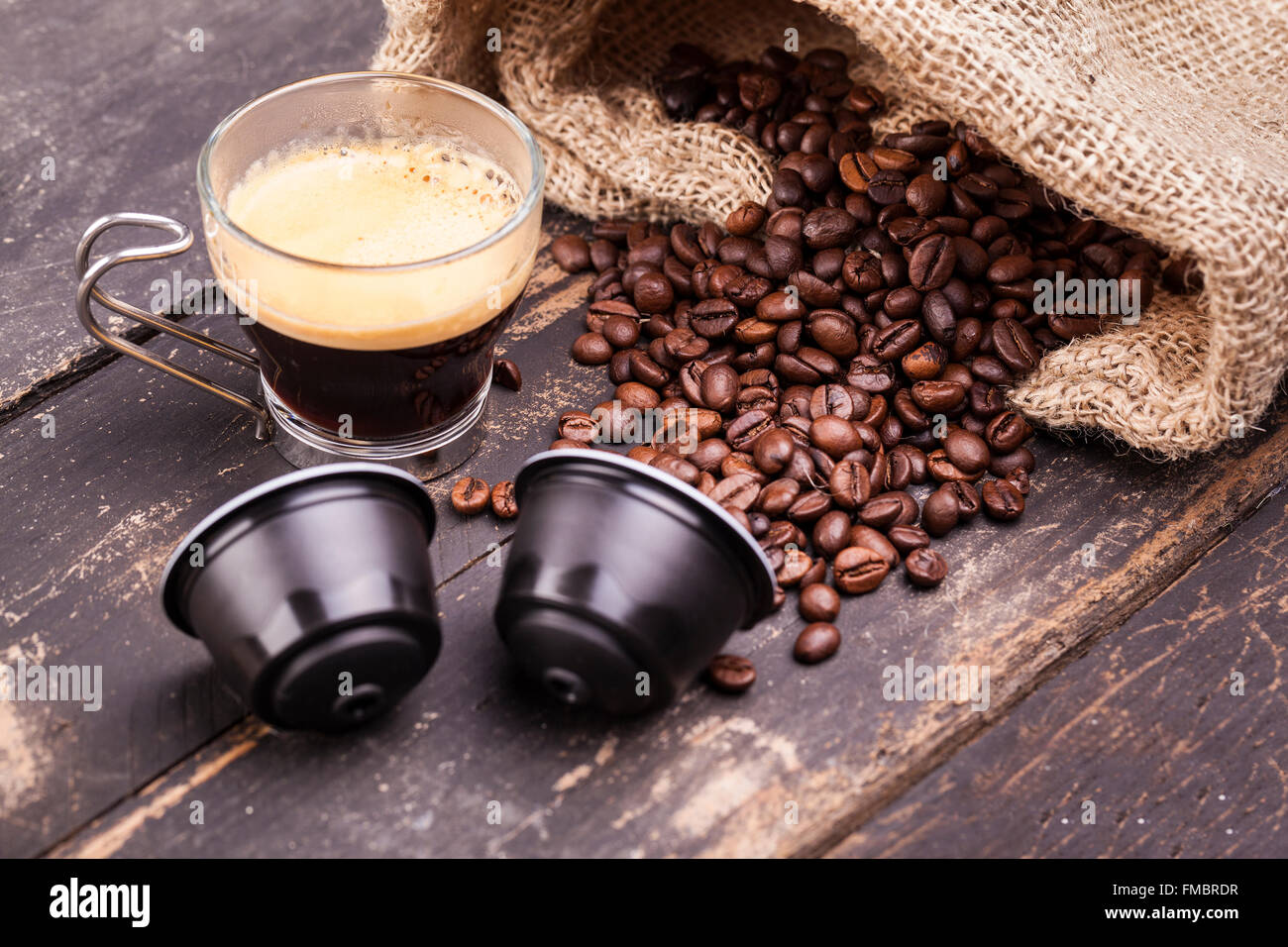 Kaffeetasse und Kapseln auf einem rustikalen Holztisch Stockfoto