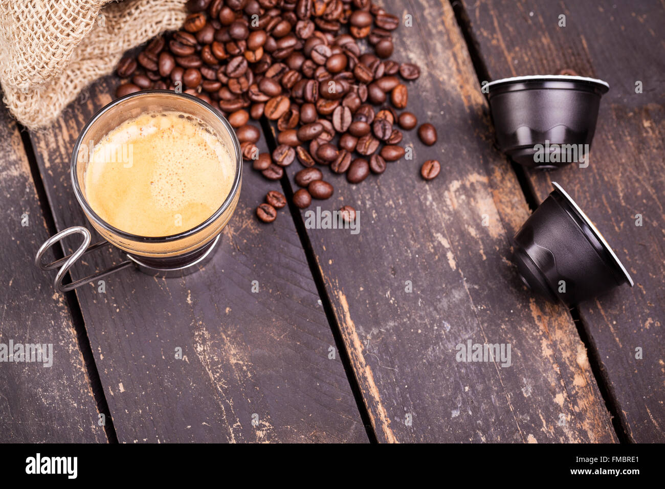 Kaffeetasse und Kapseln auf einem rustikalen Holztisch Stockfoto