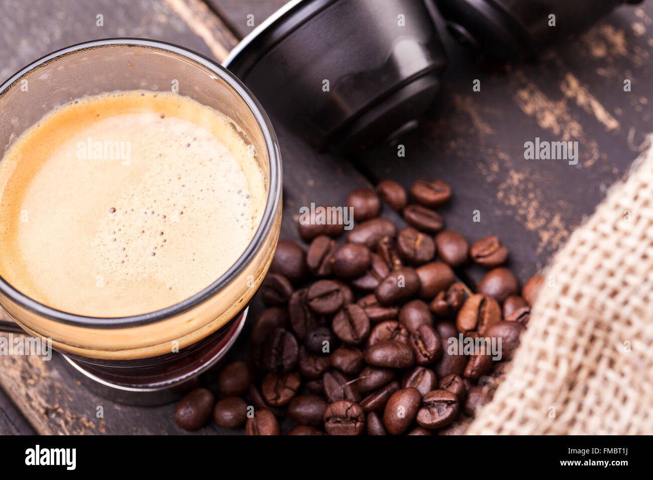 Kaffeetasse und Kapseln auf einem rustikalen Holztisch Stockfoto