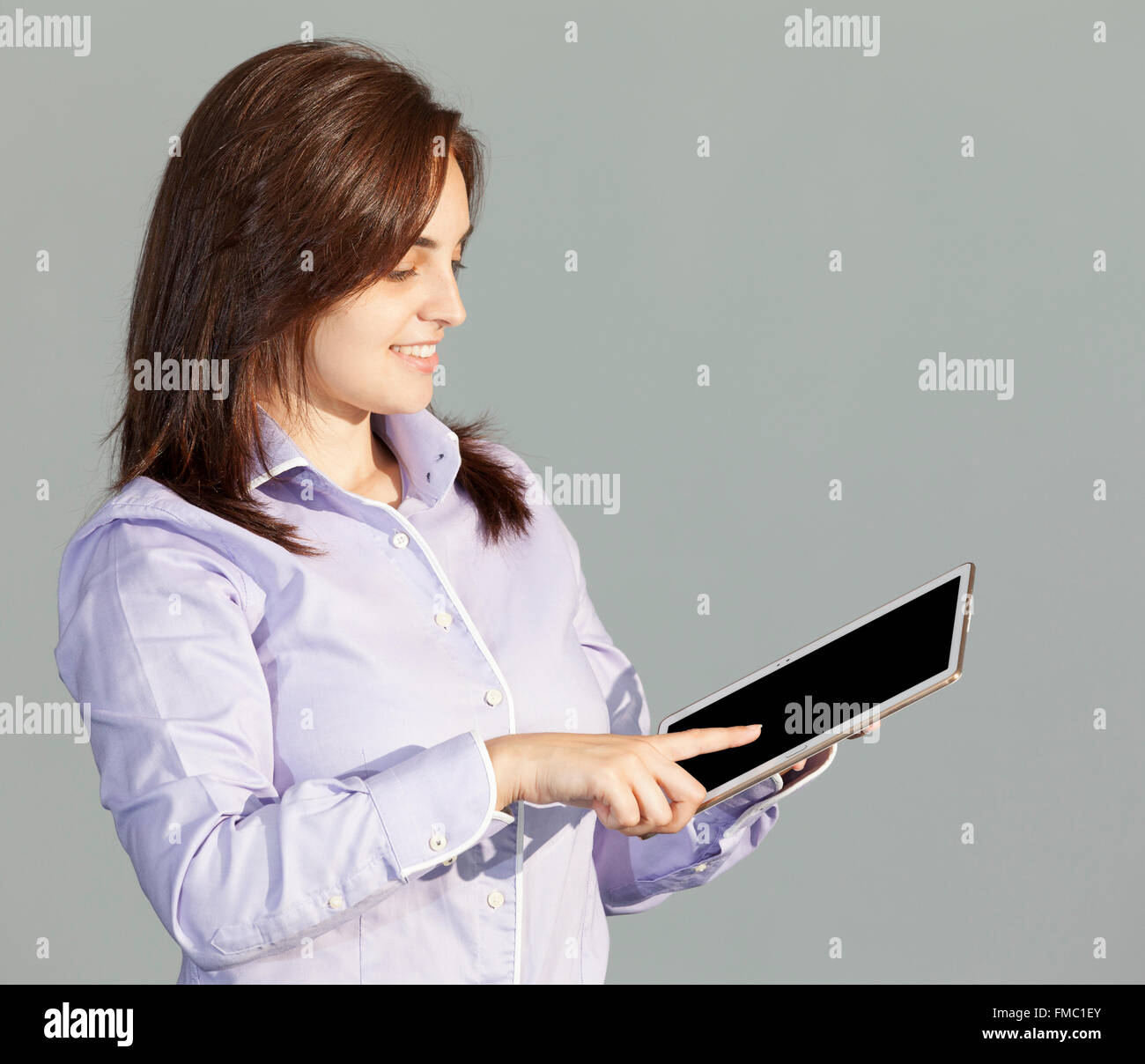 Business-Frau mit digitalen Tablet-Computer auf grauem Hintergrund Stockfoto