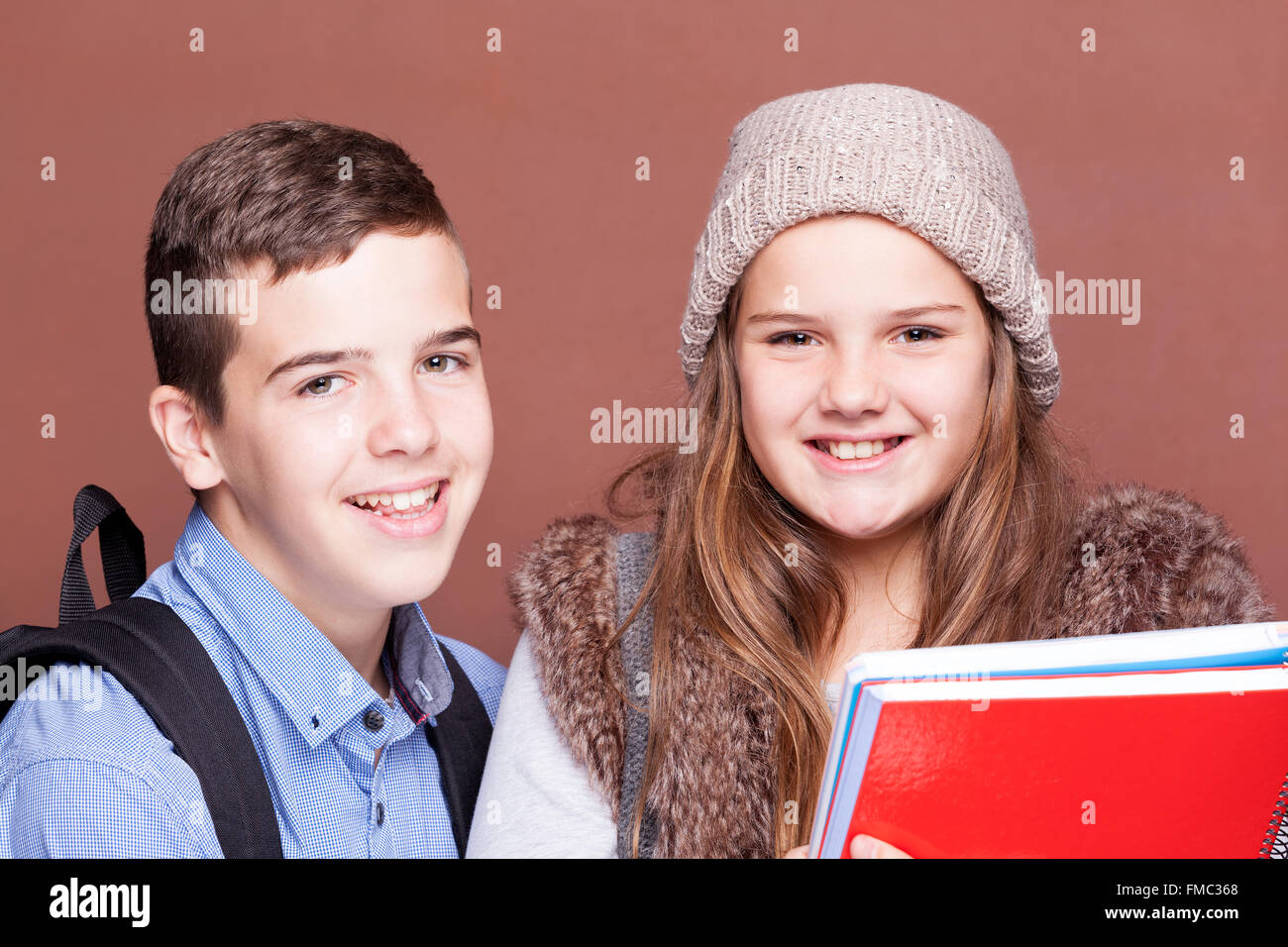 Schule Kinder stehen auf die Kamera und lächelnd auf braunen Hintergrund Stockfoto