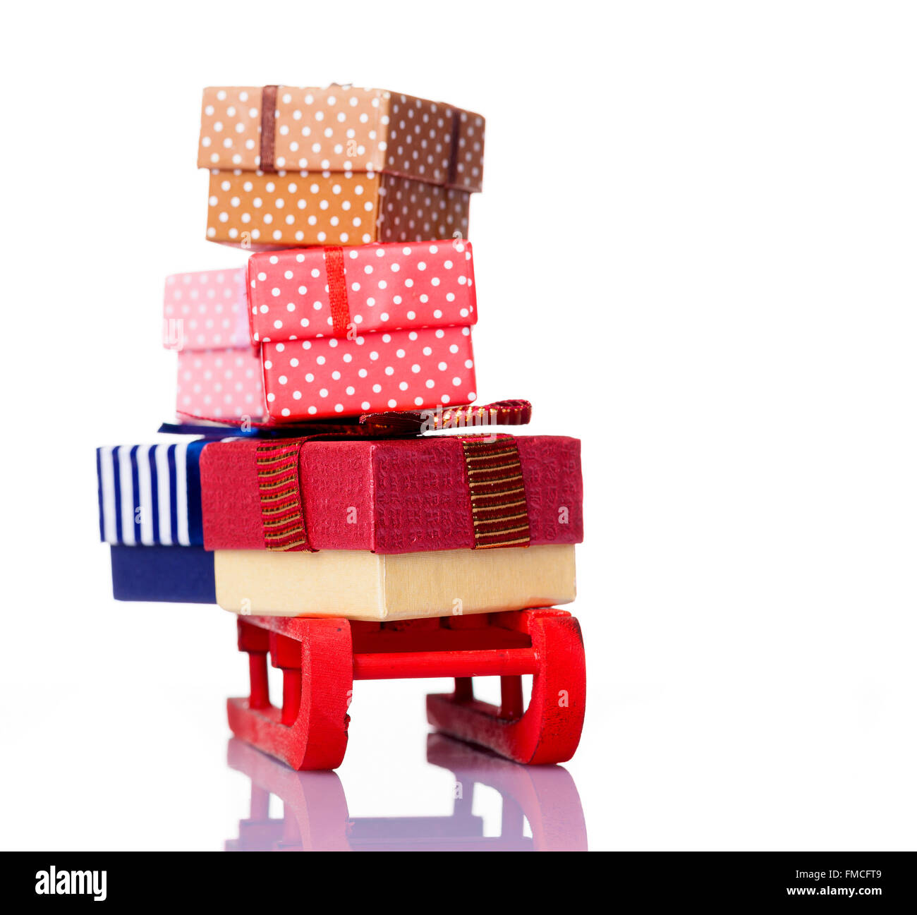 Roter Schlitten voll von Geschenk-Boxen, isoliert auf weißem Hintergrund Stockfoto
