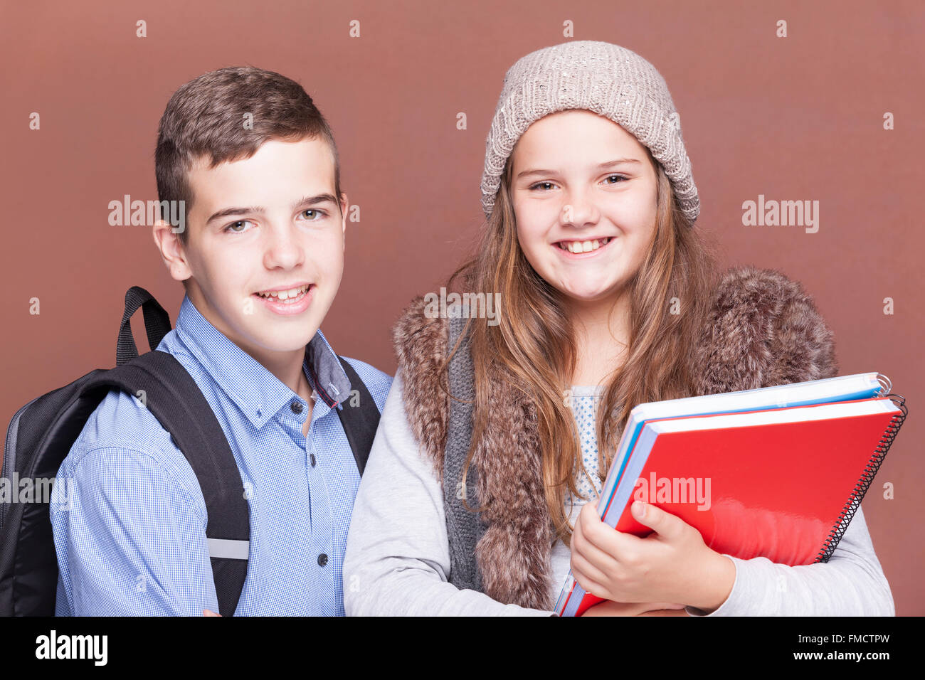 Schule Kinder stehen auf die Kamera und lächelnd auf braunen Hintergrund Stockfoto