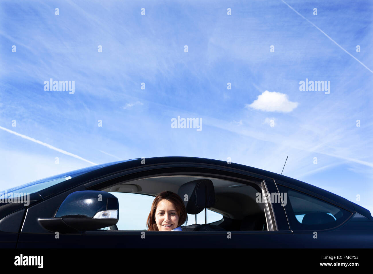 Geschäftsfrau stand lächelnd innerhalb eines Sportwagens Stockfoto