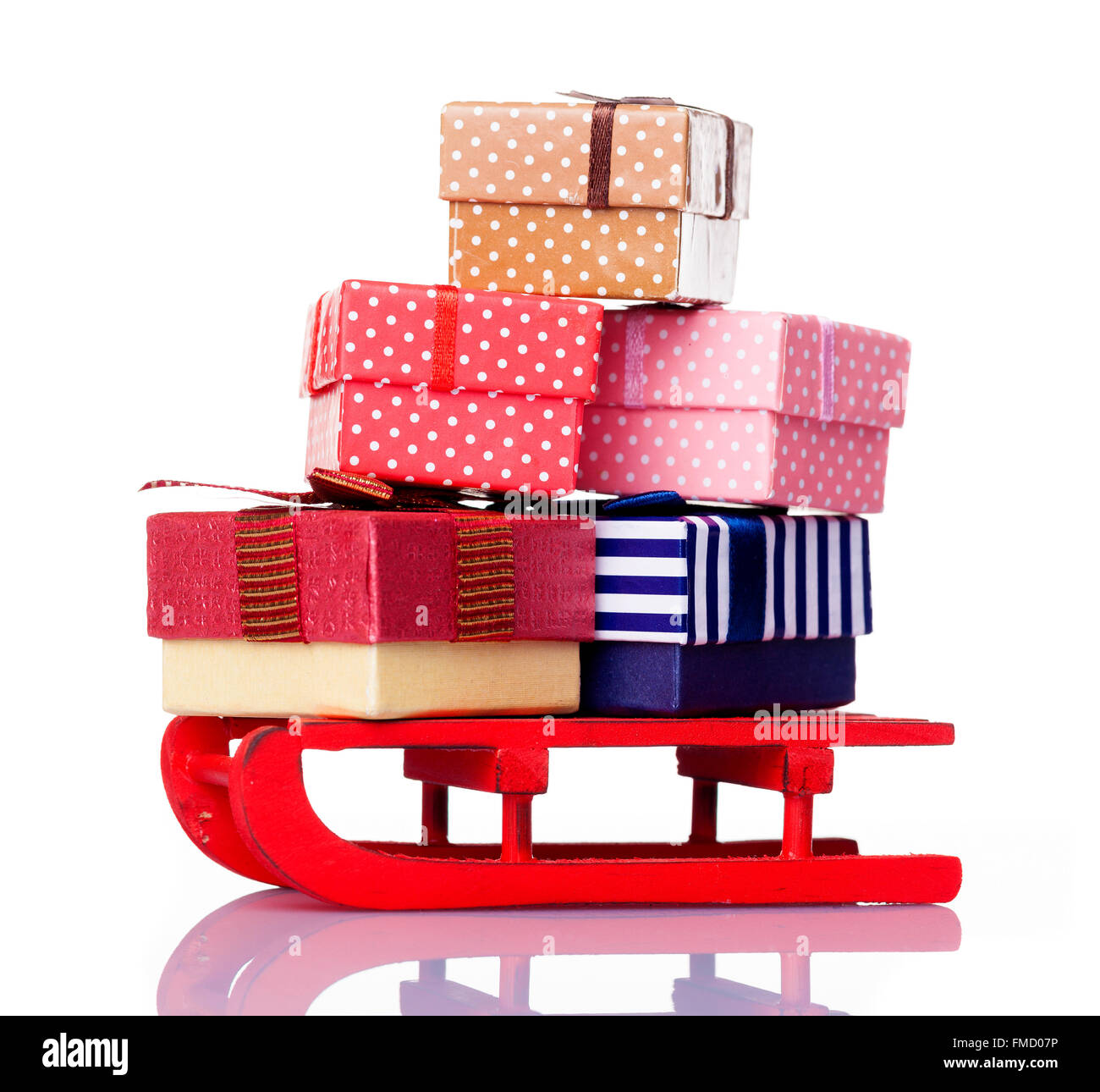 Roter Schlitten voll von Geschenk-Boxen, isoliert auf weißem Hintergrund Stockfoto