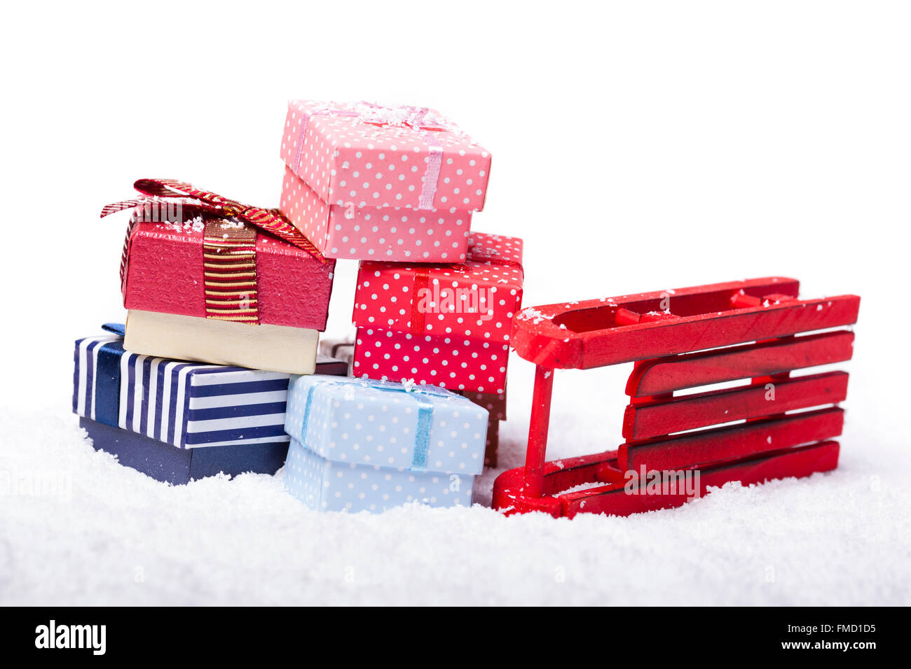 Roter Schlitten und Geschenk-Boxen auf weißem Hintergrund Stockfoto