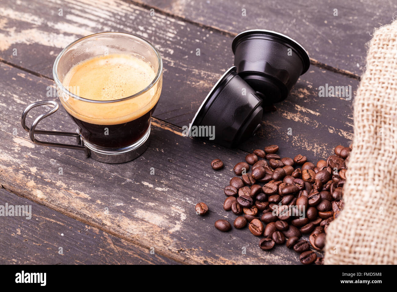 Kaffeetasse und Kapseln auf einem rustikalen Holztisch Stockfoto