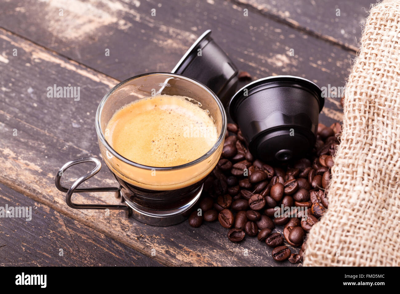 Kaffeetasse und Kapseln auf einem rustikalen Holztisch Stockfoto