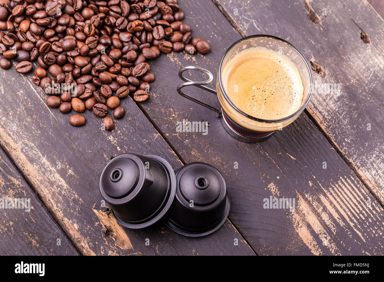 Kaffeetasse und Kapseln auf einem rustikalen Holztisch Stockfoto