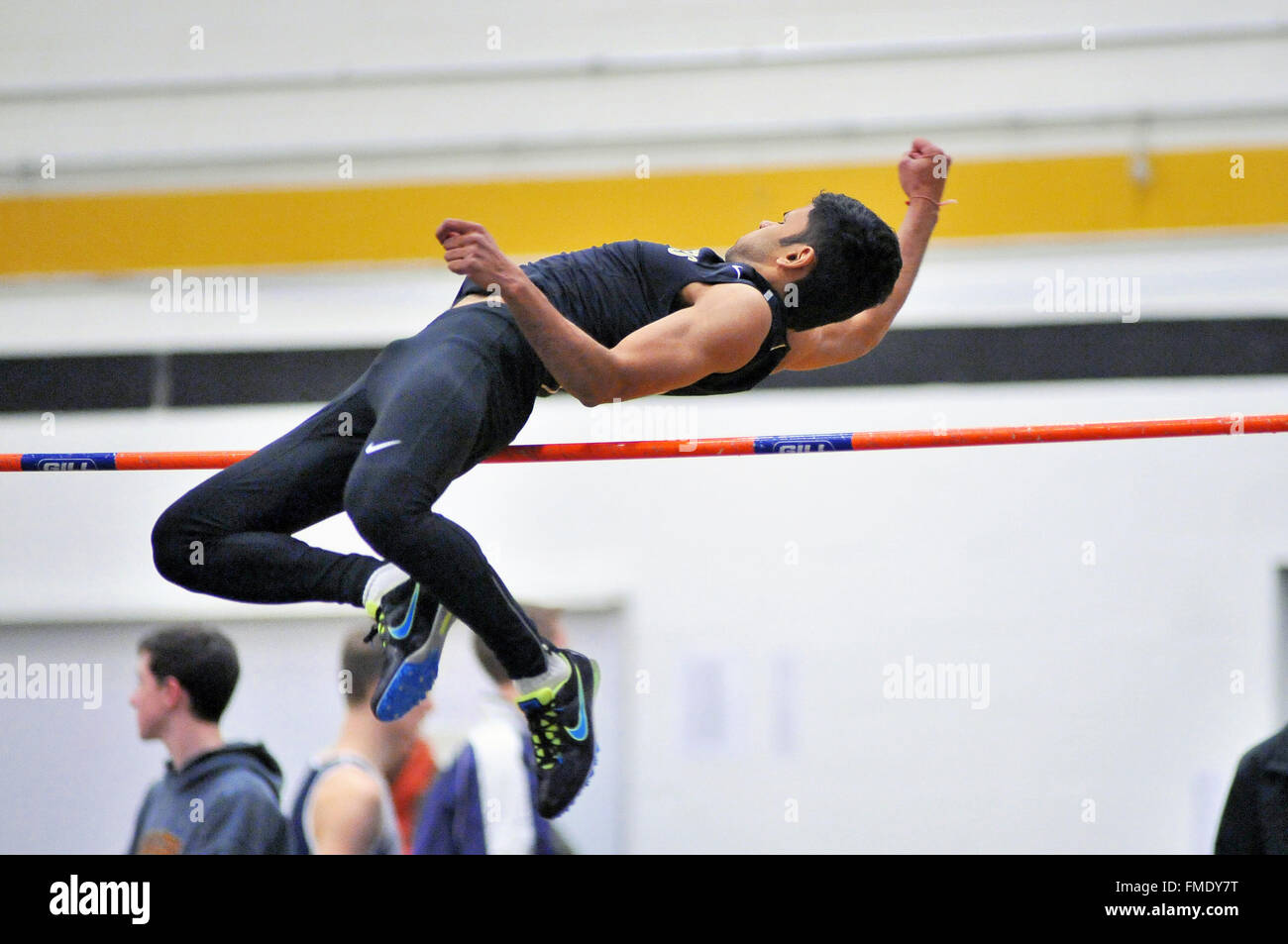 Ein High School Athlet versucht, den hohen Sprung bar zu löschen Bei einem Indoor treffen. USA. Stockfoto