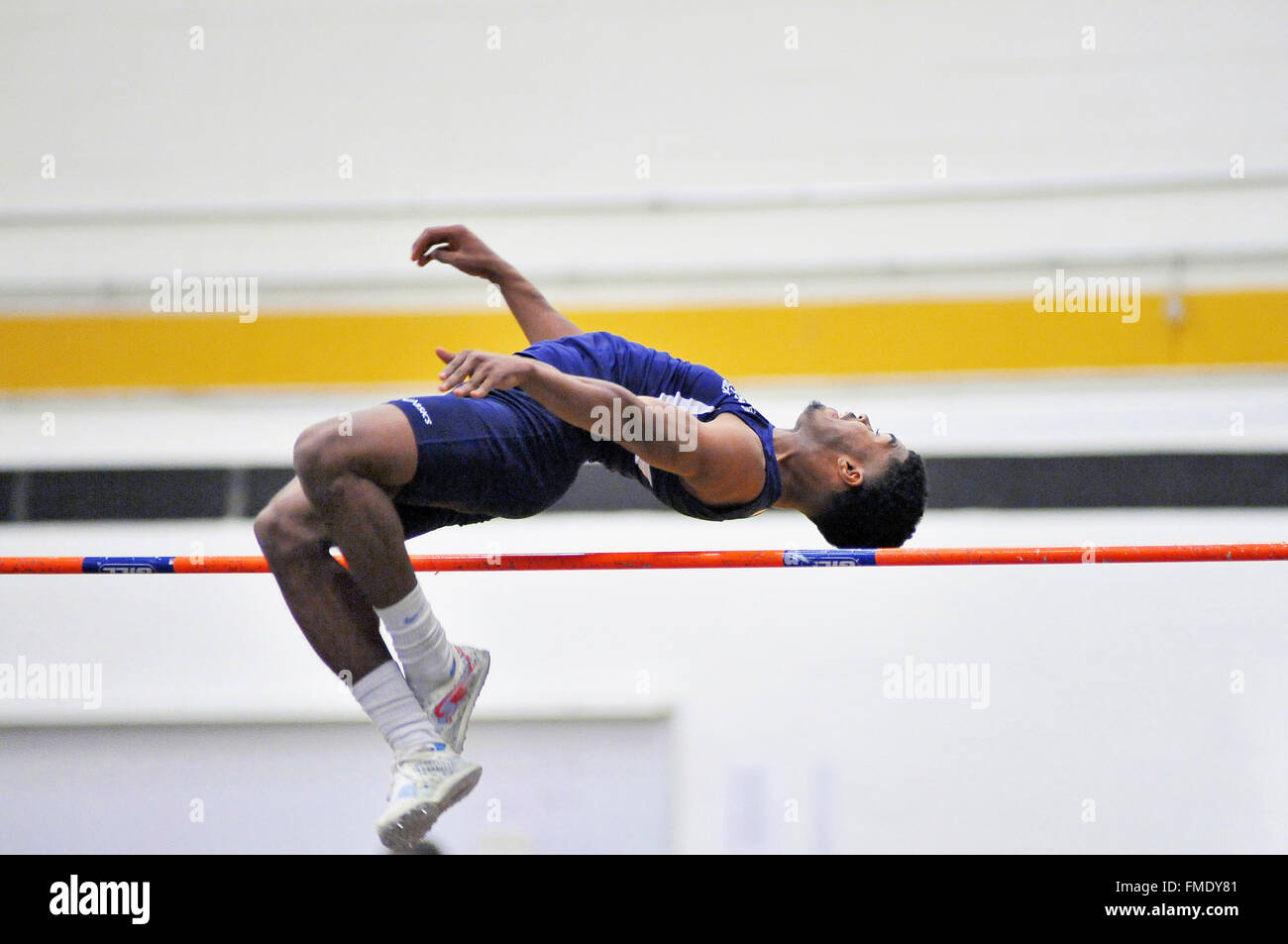 Ein High School Athlet versucht, den hohen Sprung bar zu löschen Bei einem Indoor treffen. USA. Stockfoto