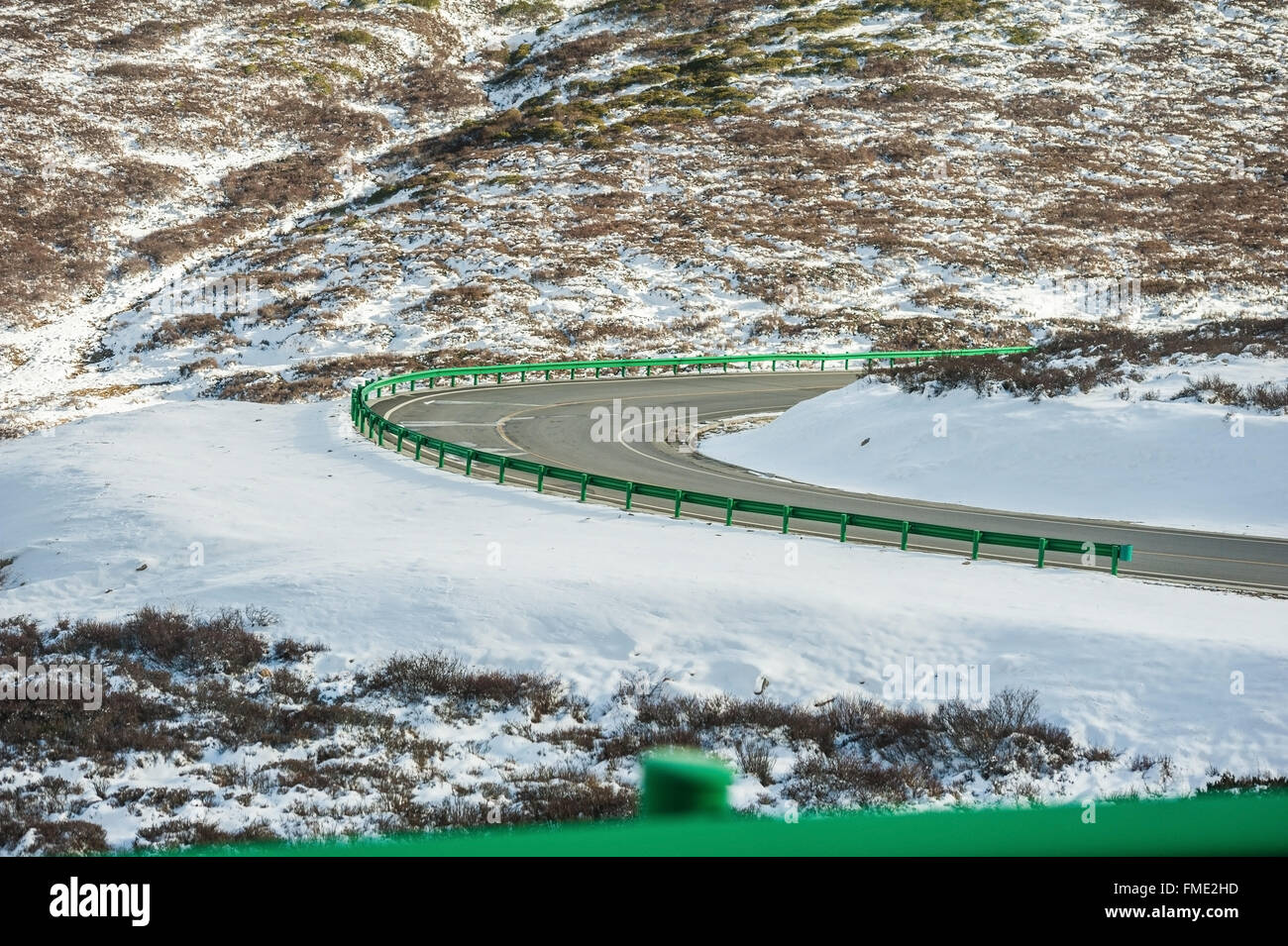 Straße in die schneebedeckten Berge Stockfoto
