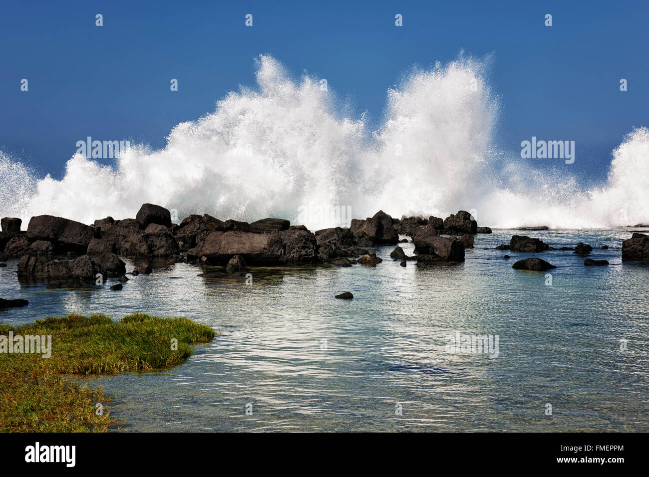 Wellen gegen die Lava Küstenlinie und überfluten die Gezeiten-Pools am Wawaloli Beach auf der Big Island von Hawaii. Stockfoto