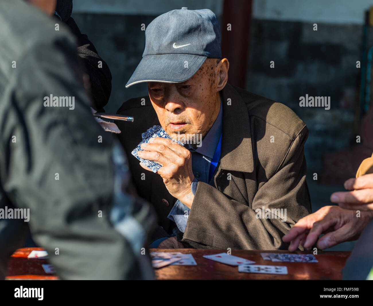 Porträt einer älteren chinesischen Männer genießen ein Kartenspiel mit Freunden Stockfoto