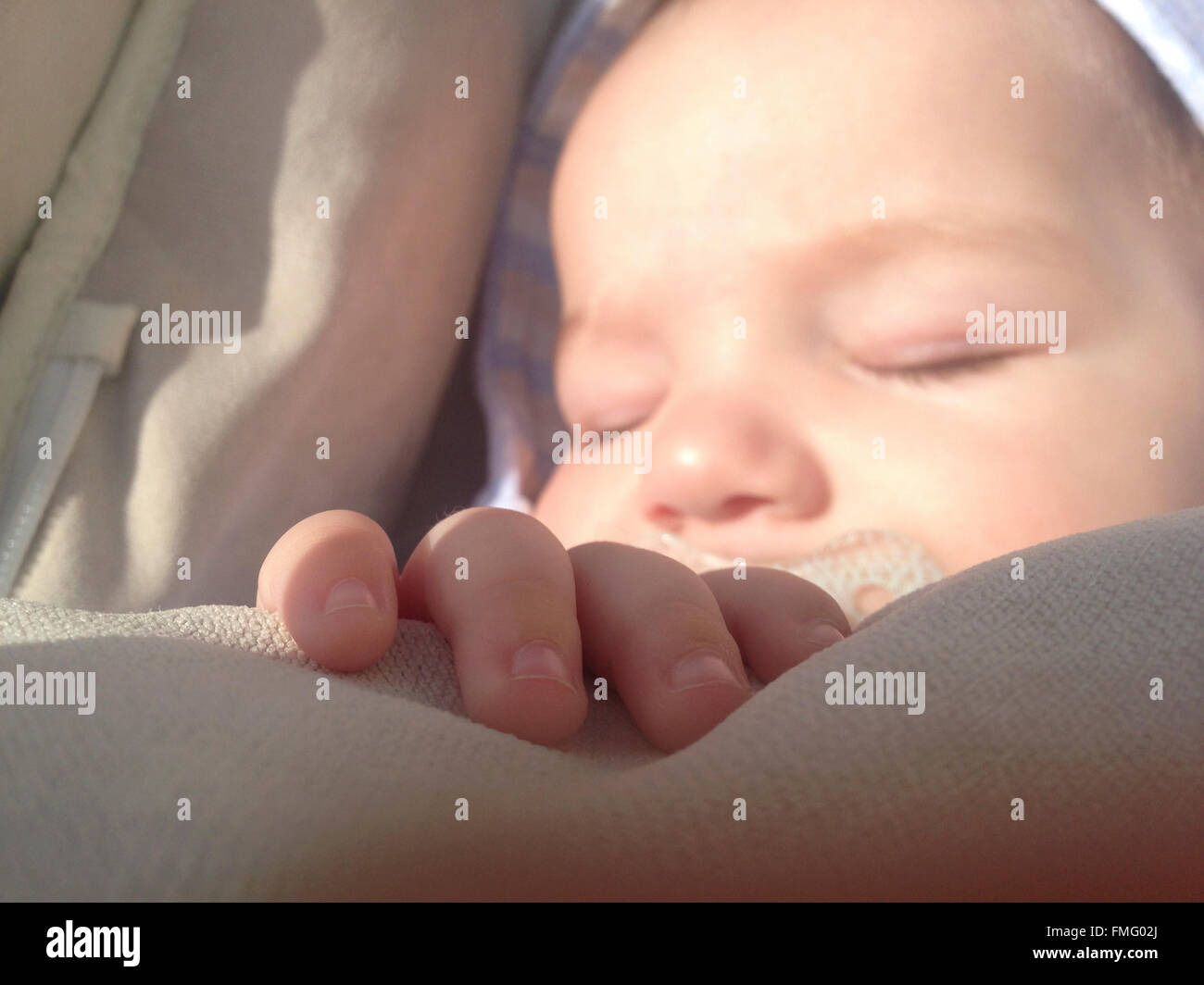 Detail von Hand auf vier Monate Jungen schlafen. Er liegt im Kinderwagen. Closeup Stockfoto