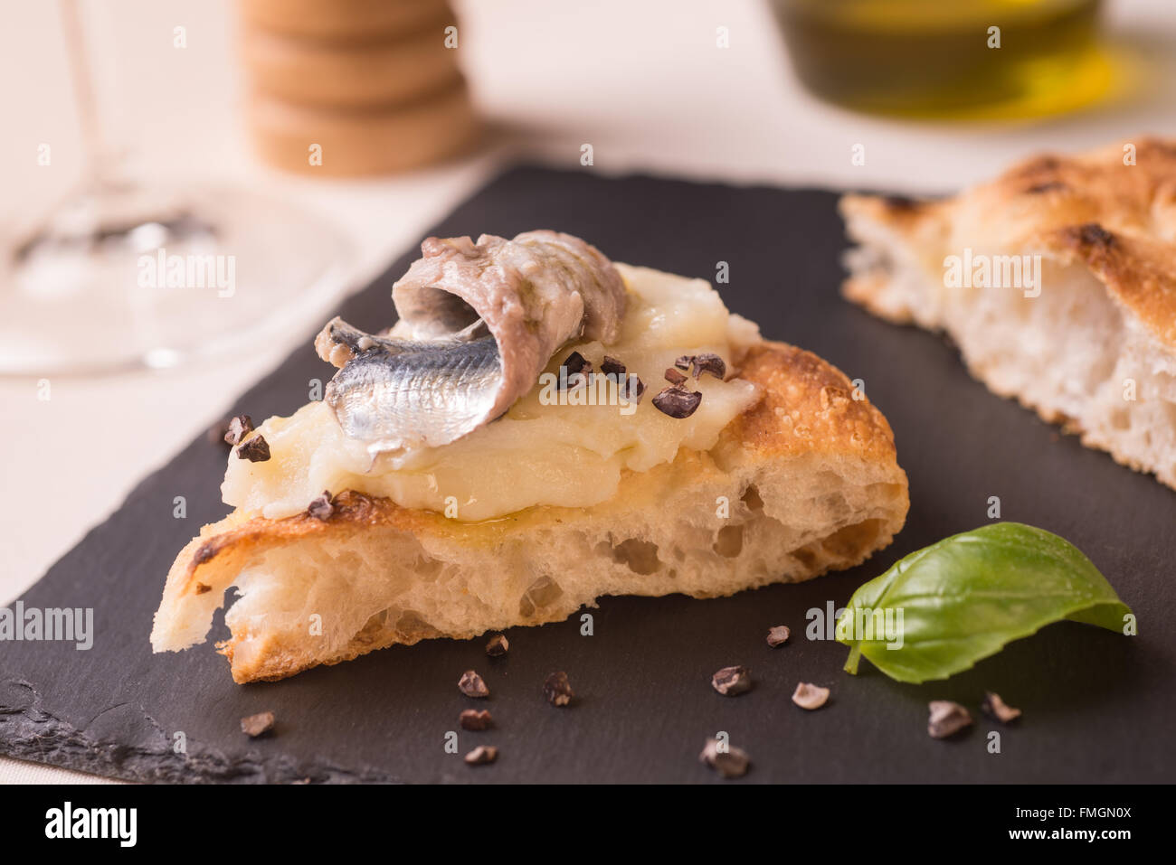 Scheibe der Pizza Gourmet mit Kartoffeln Sahne, marinierte Sardellen und geriebenem Rohkakao Stockfoto