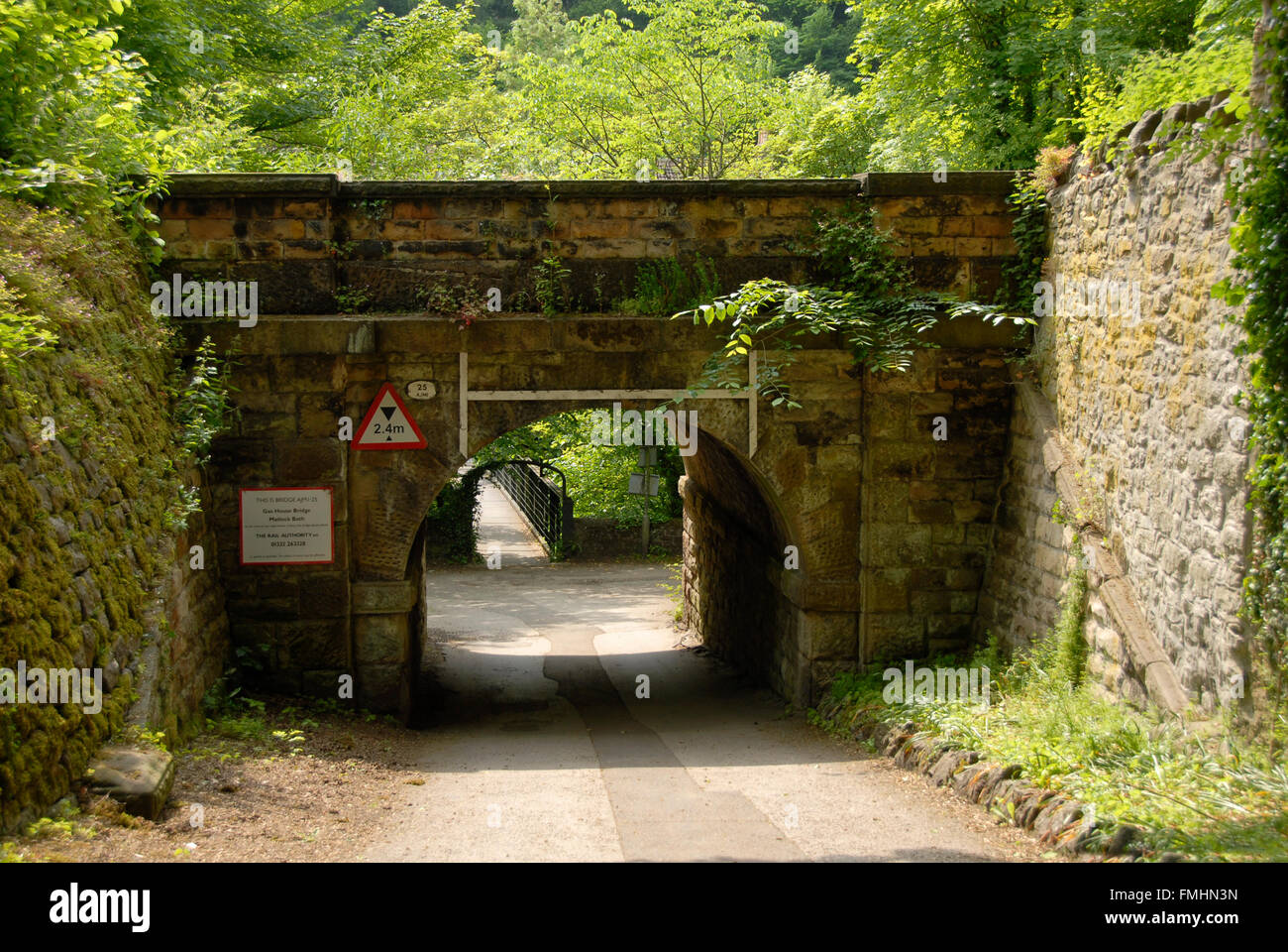Niedrige, schmale Eisenbahnbrücke über Straße Stockfoto
