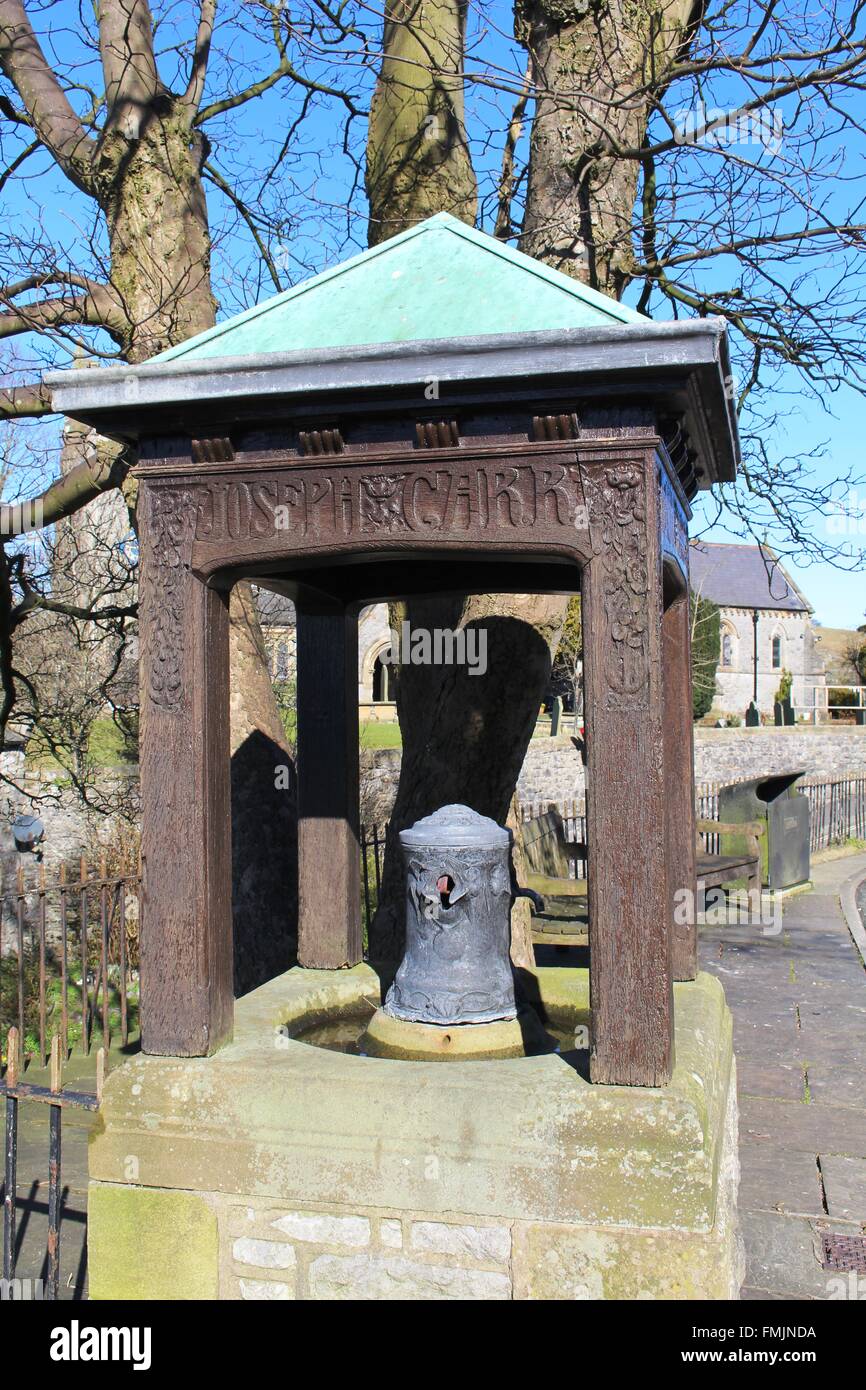 Wasser Gedenkbrunnen für Joseph Carr mit geschnitzten hölzernen Einfassung auf der Hauptstraße in Ingleton, North Yorkshire, England. Stockfoto