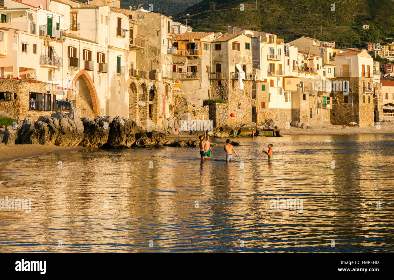 Abendstimmung, Jugendliche spielen am Strand, Hafen, Altstadt von Cefalù, Provinz von Palermo, Sizilien, Italien Stockfoto