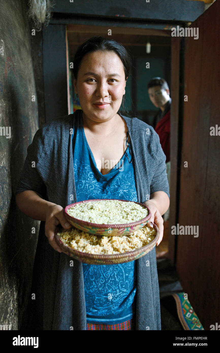 Frau, 30 Jahre alt, hält Reis Schalen, Distrikt Paro, Bhutan Stockfoto