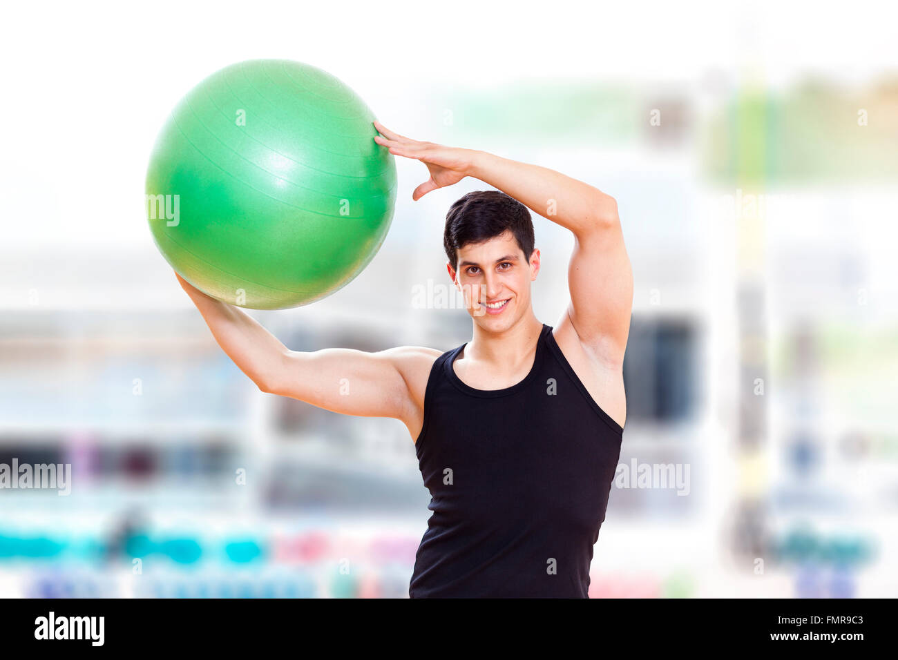 Junger sportlicher Mann Ausübung Workout Fitness-Ball in der Turnhalle Stockfoto