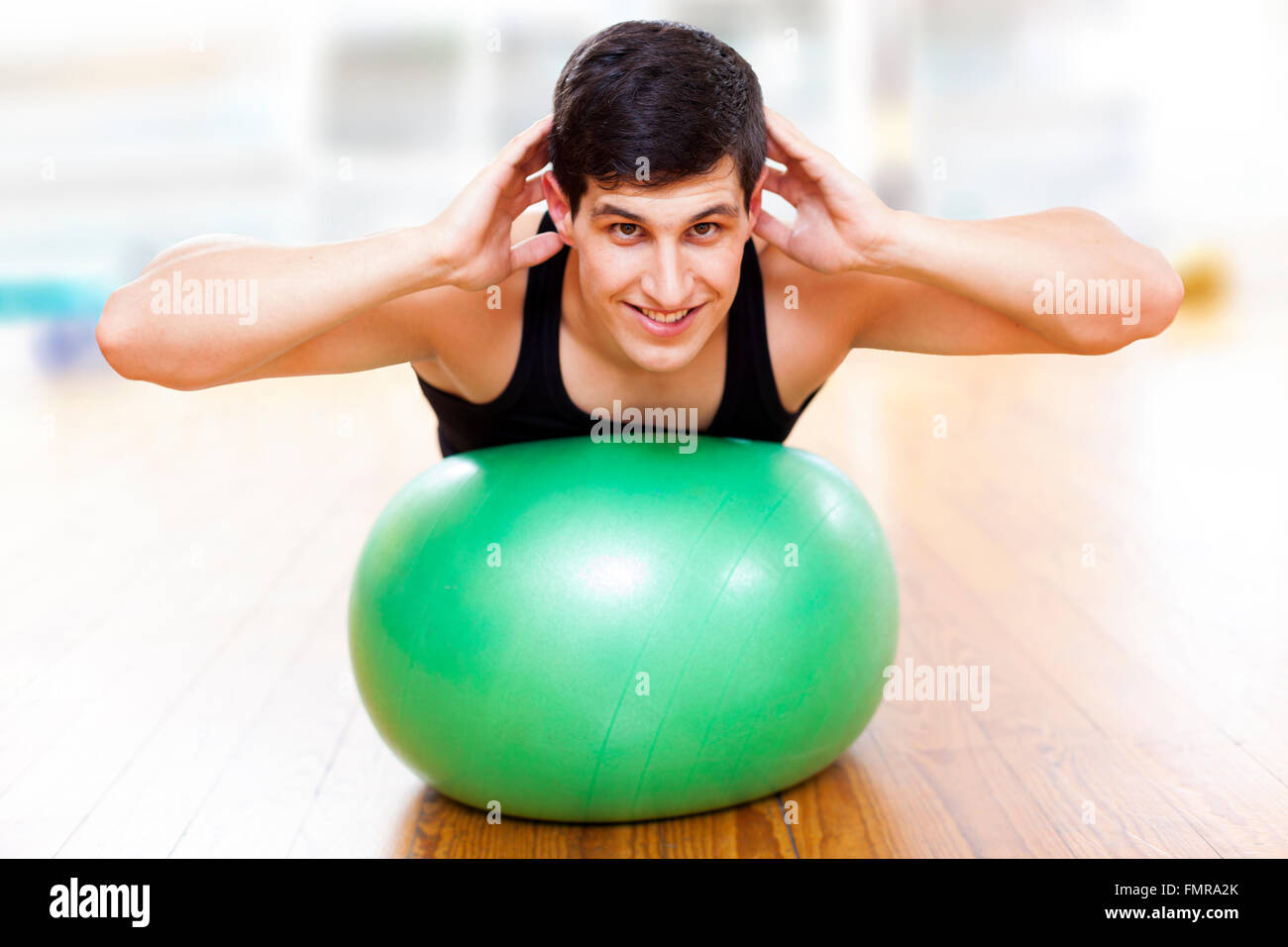 Junger sportlicher Mann Ausübung Workout Fitness-Ball in der Turnhalle Stockfoto