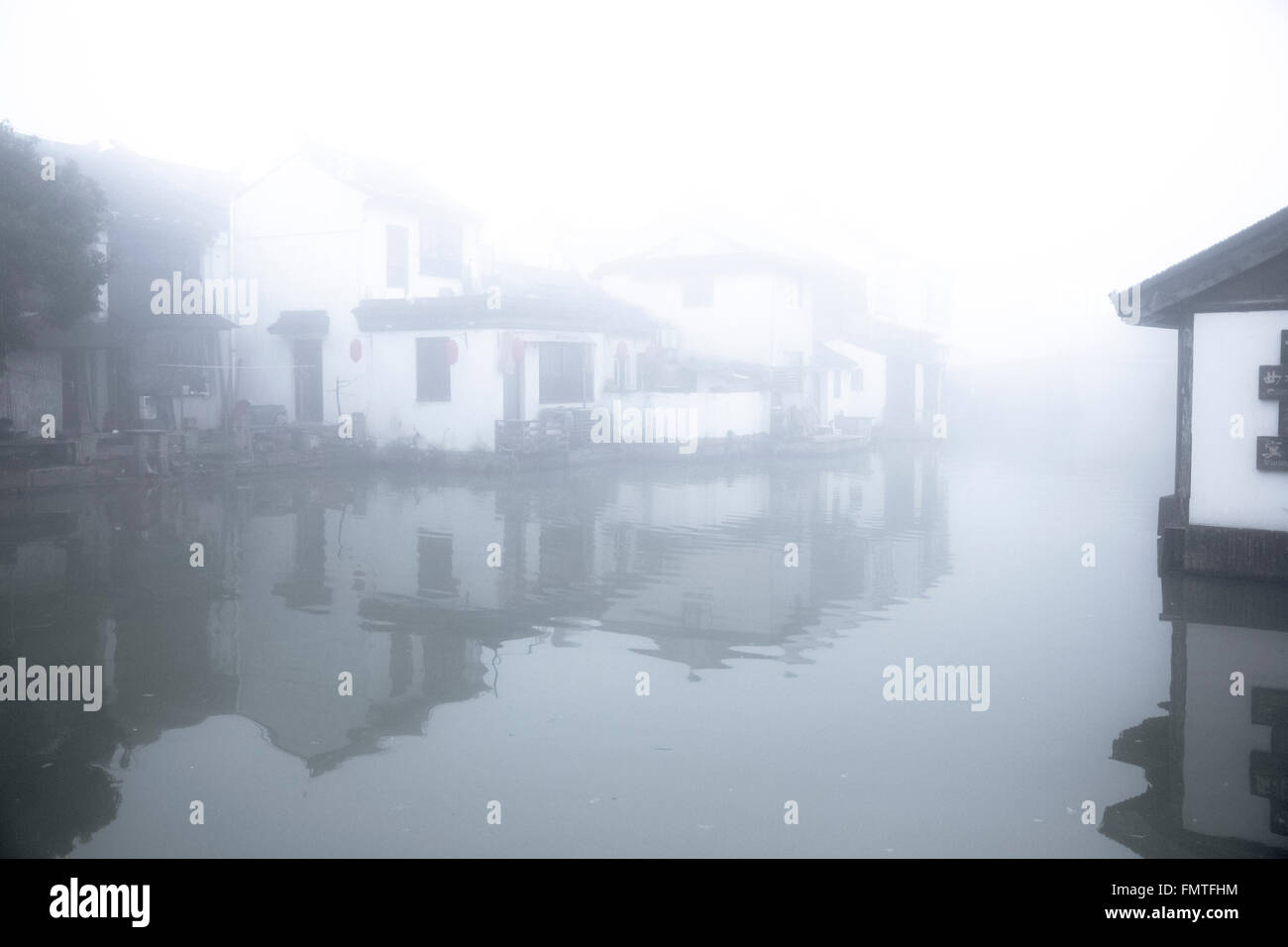 Wie chinesische undurchsichtige Aquarell, kleine Häusern im Wasser stehen. Dichter Nebel macht die Stadt zu Traum, ein Traum in weiß. Stockfoto
