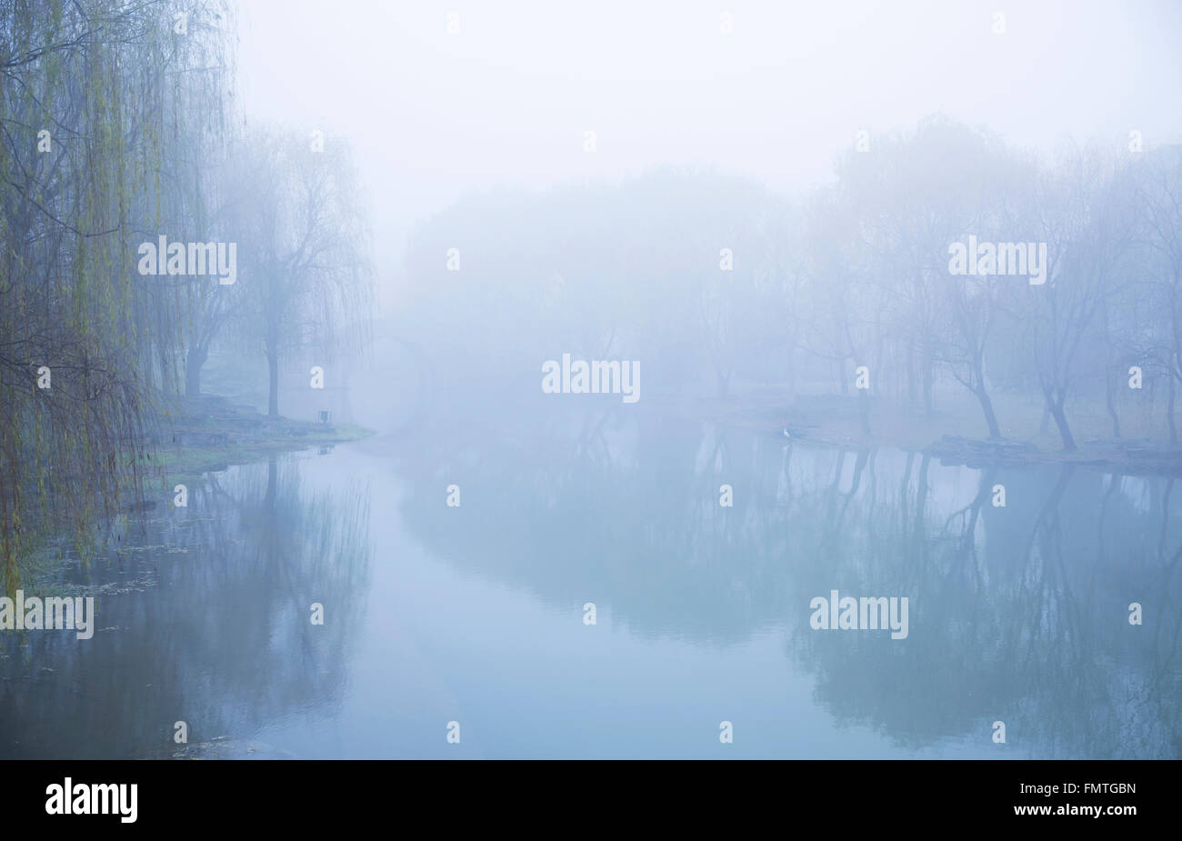Wie chinesische undurchsichtige Aquarell, kleiner See umgeben das Dorf. Dichter Nebel macht das Dorf zu Traum, ein Traum in weiß. Stockfoto
