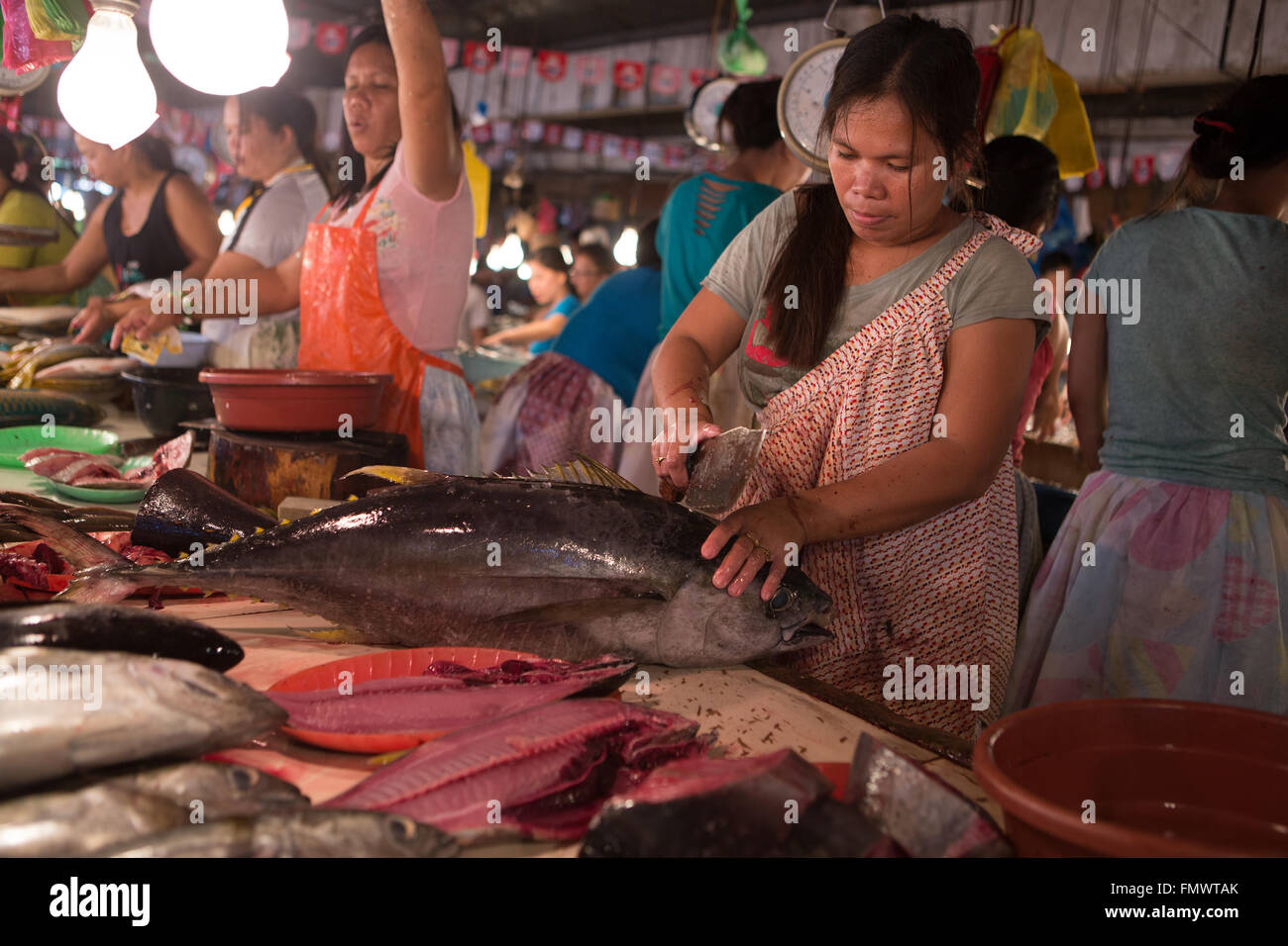 Eine Frau, die einen frischen Thunfisch, im Markt Talisay, Cebu City, Philippinen gut vorbereiten Stockfoto