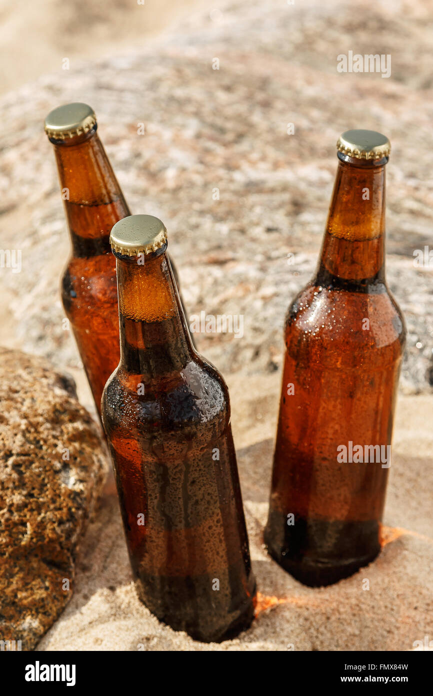 Objekt Foto. Kaltes Bier in braunen Flasche mit Glas am schönen Sandstrand.  Konzepte von Urlaub und Ferien Stockfotografie - Alamy