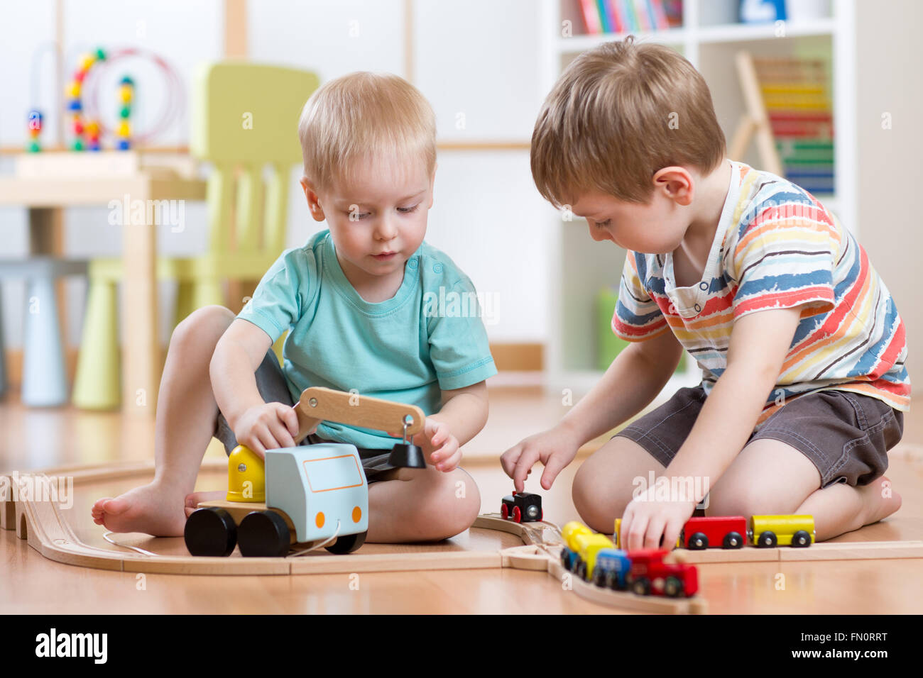 Kinder Jungen spielen Eisenbahn zusammen im Spielzimmer Stockfoto