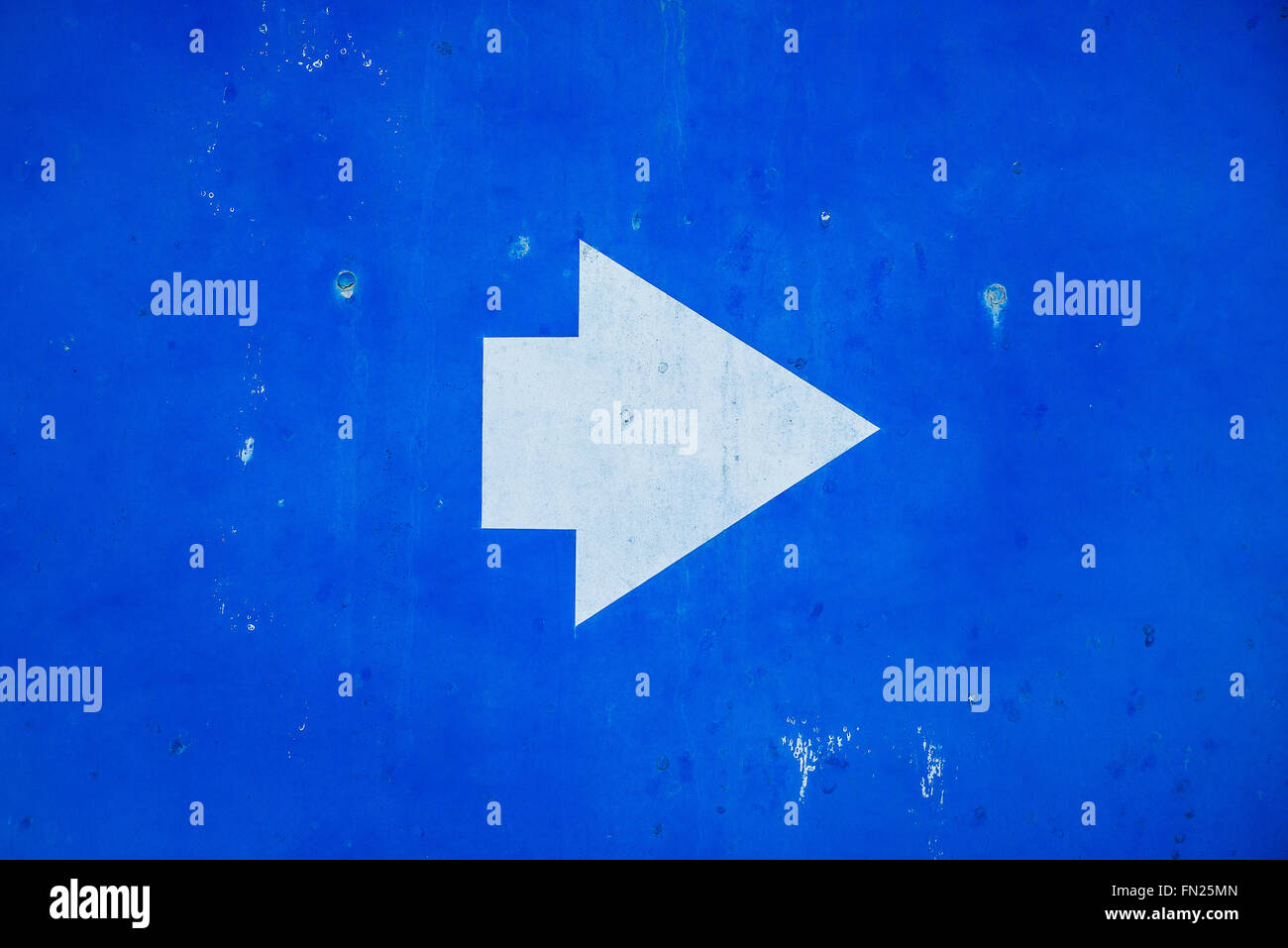 Richtungszeichen weißen Pfeil-Symbol auf Metall blau lackierten Grunge Hintergrund. Stockfoto