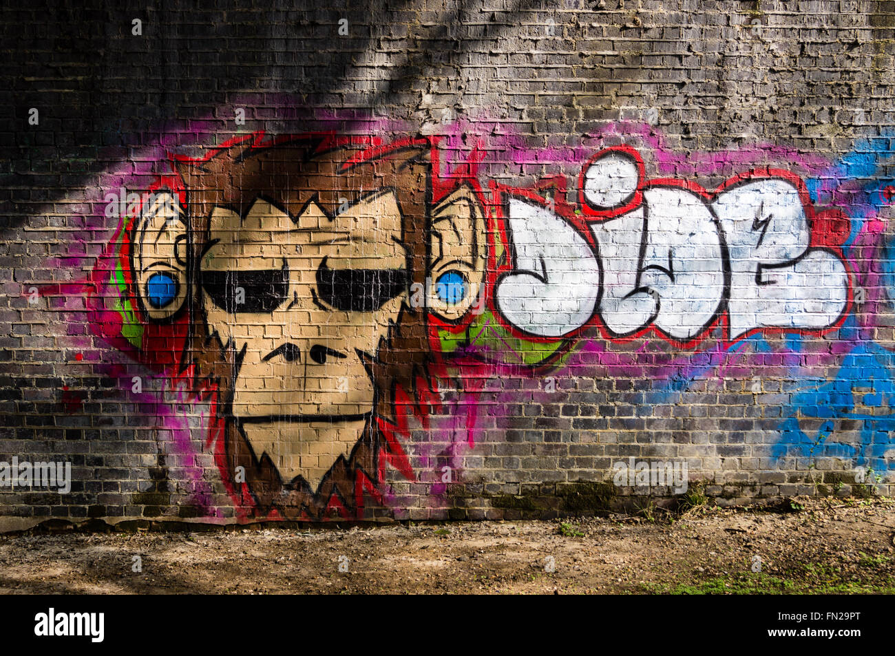 Graffiti von einem Affen Kopf auf eine Eisenbahnbrücke über den Fluss Roding, Buckhurst Hill, Essex, England Stockfoto