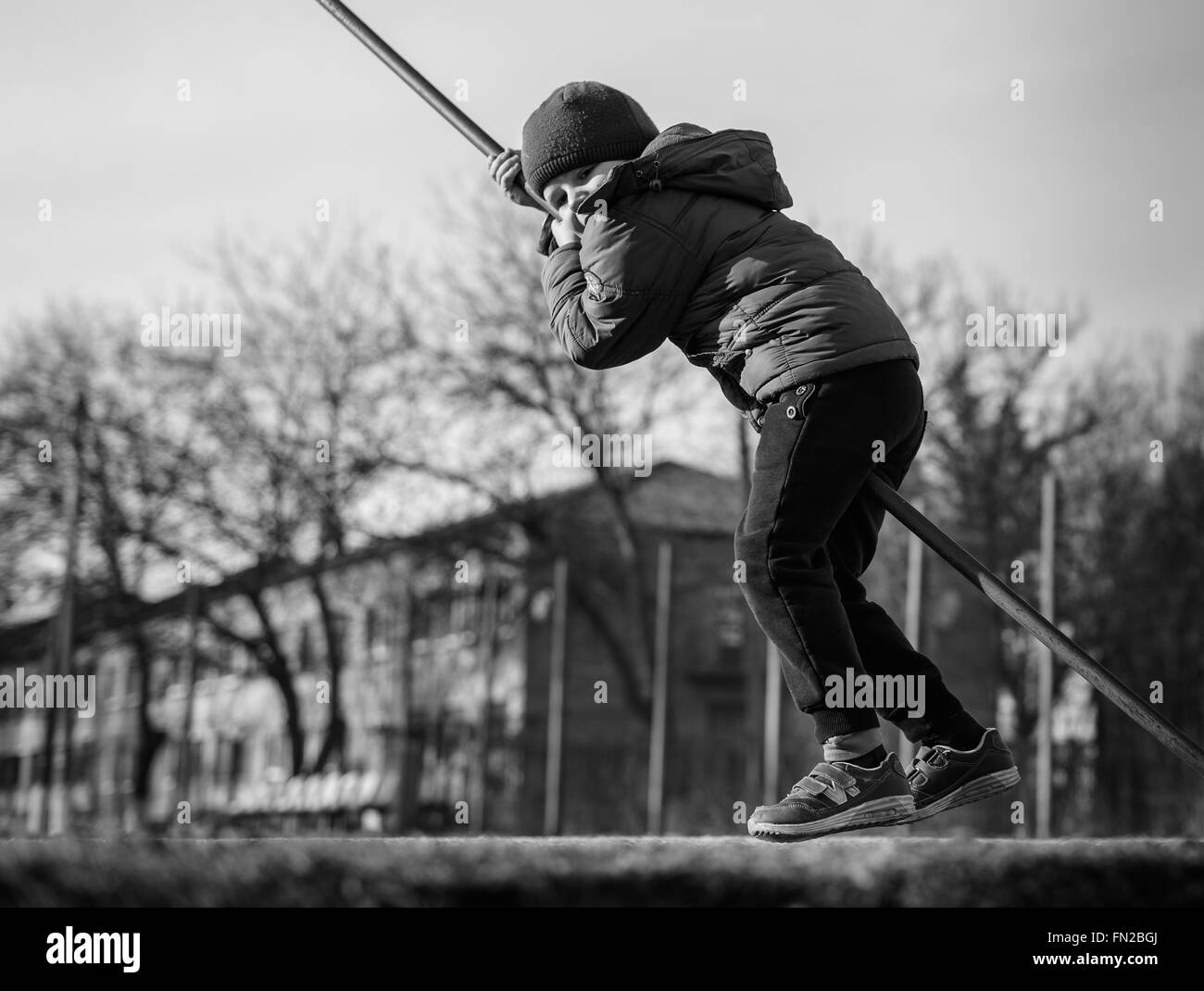 kleiner Junge spielt auf dem Sport-Spielplatz für Maschendrahtzaun Stockfoto