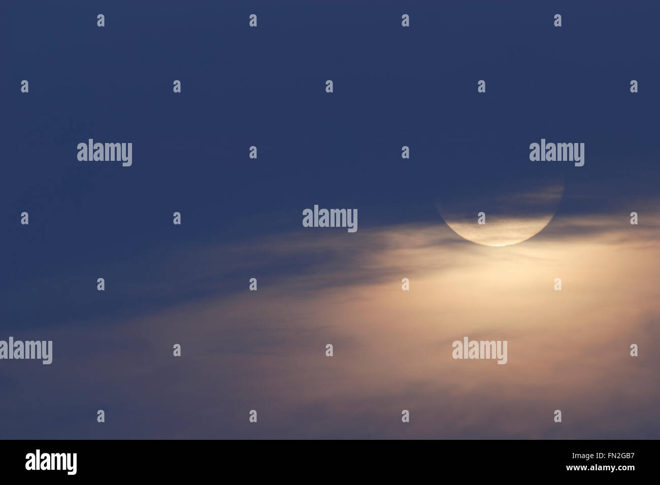 Mondaufgang zur blauen Stunde, in der Dämmerung, teils versteckt hinter hohen Nebel, Wolken, nette Atmosphäre im November. Stockfoto