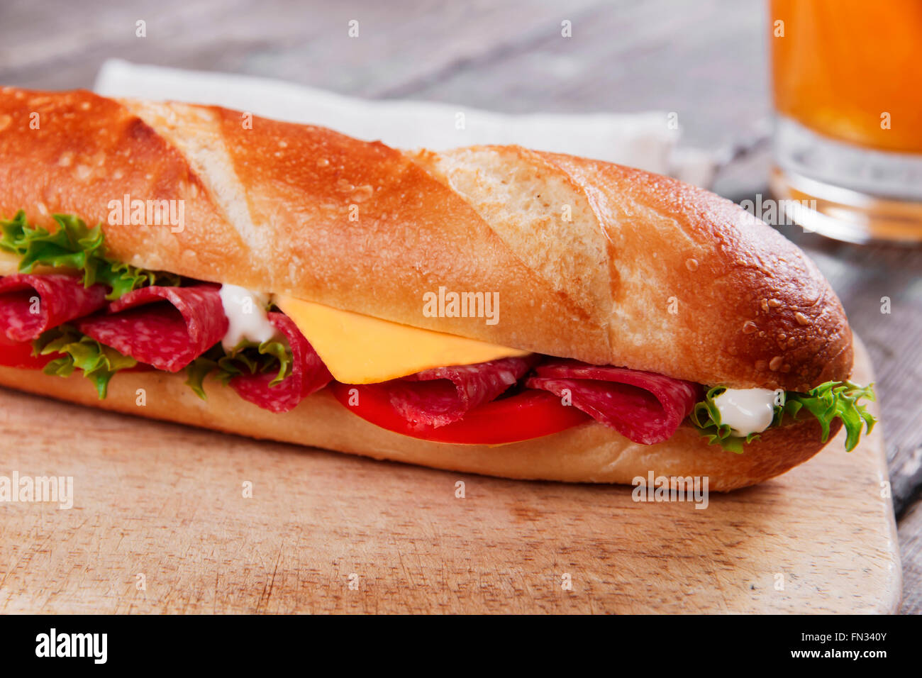 Sandwich-Baguette-Käse-Salami-Tomaten-Sauce und Kräuter Stockfoto