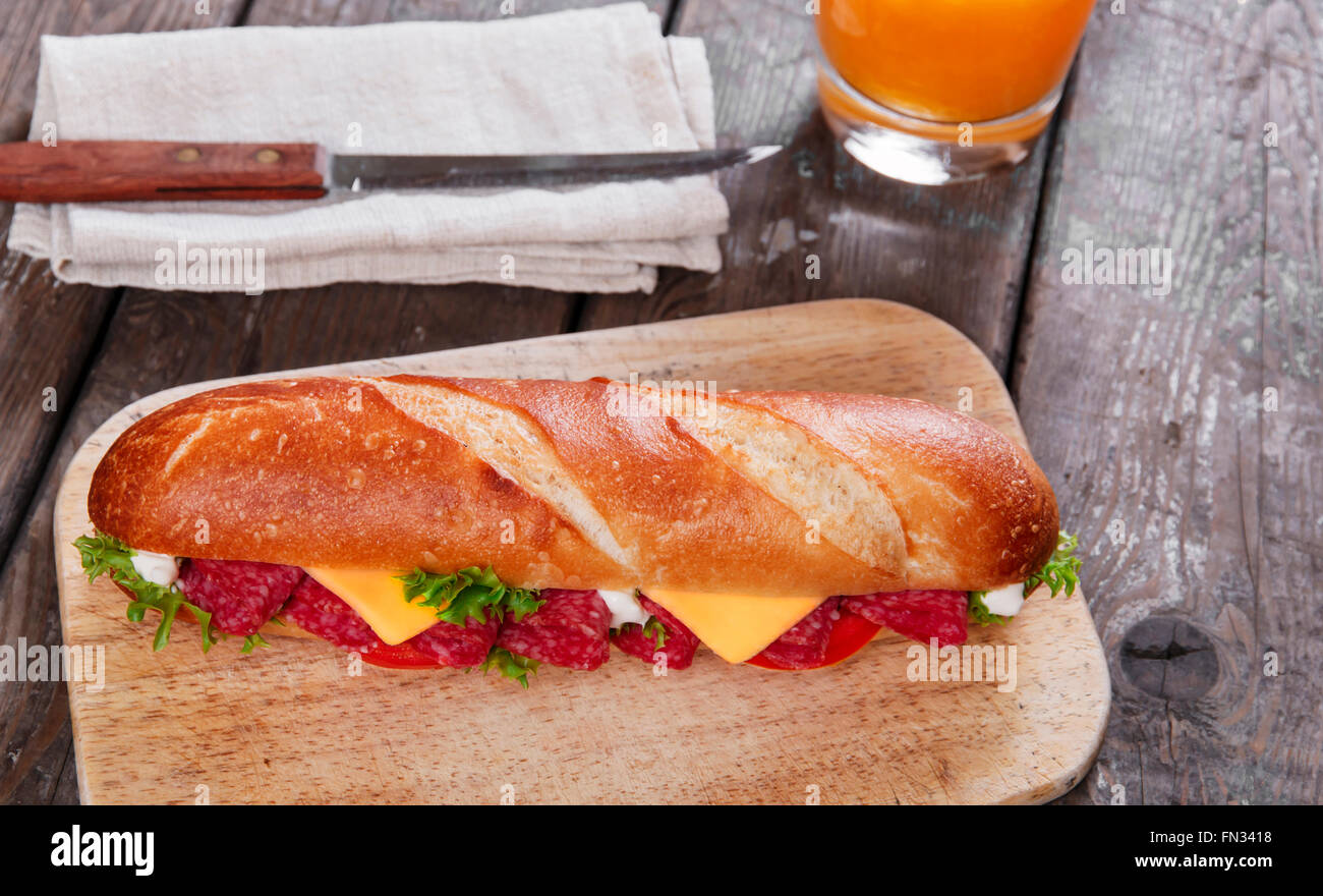 Sandwich-Baguette-Käse-Salami-Tomaten-Sauce und Kräuter Stockfoto