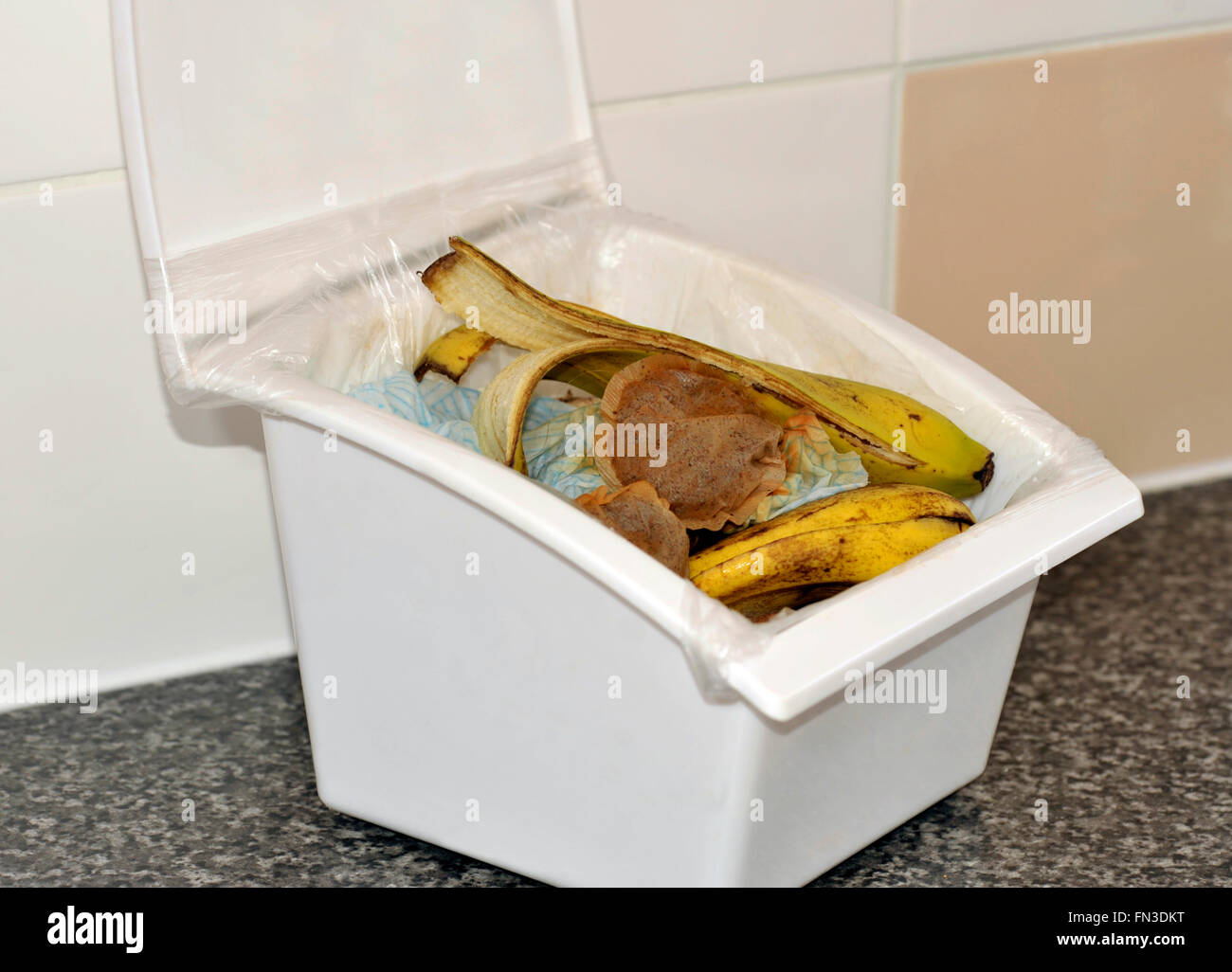 Küche Speisereste in einer Lidern sammeln Box mit Papier, Teebeutel und Banana Skins für recycling im Hause Kompost. Stockfoto
