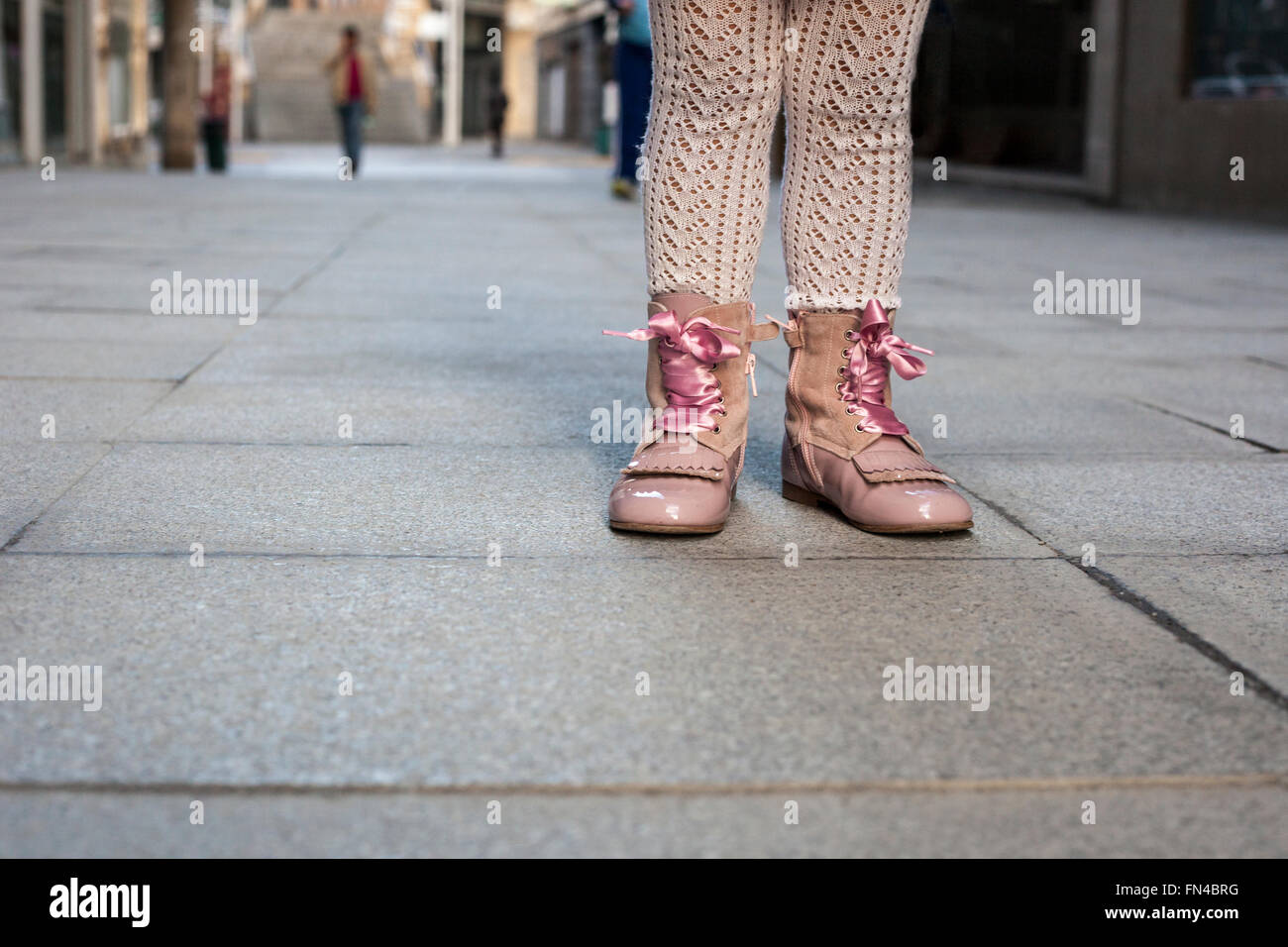 Glückliches drei Jahres altes Mädchen tragen rosa satin Spitze Stiefel auf die Stadt. Nahaufnahme Stockfoto