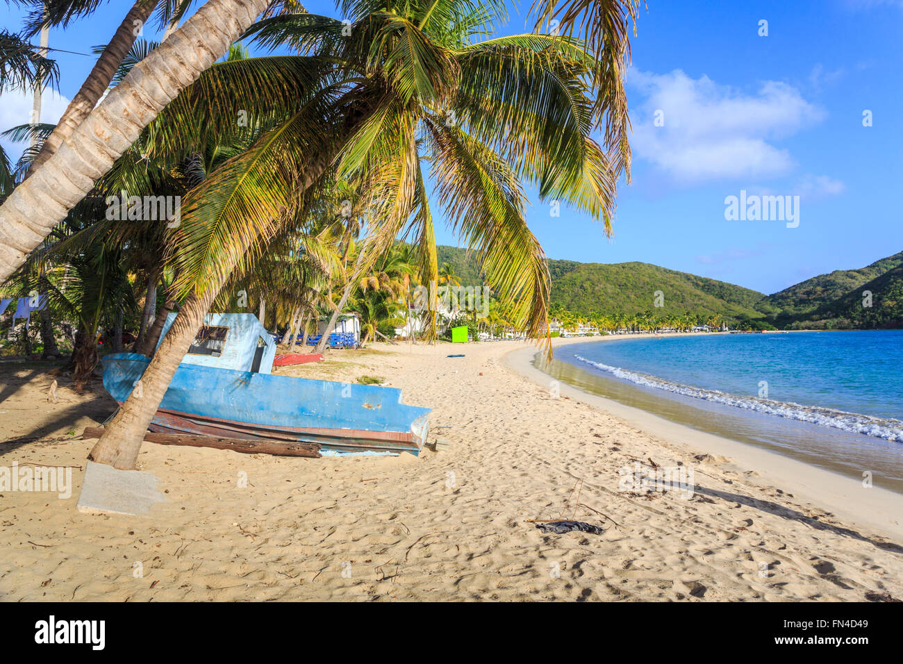 Antiguan Sightseeing: Verlassene blau Holz- Boot am Strand unter Palmen an der Carlisle Bay, Antigua, Antigua und Barbuda, West Indies Stockfoto