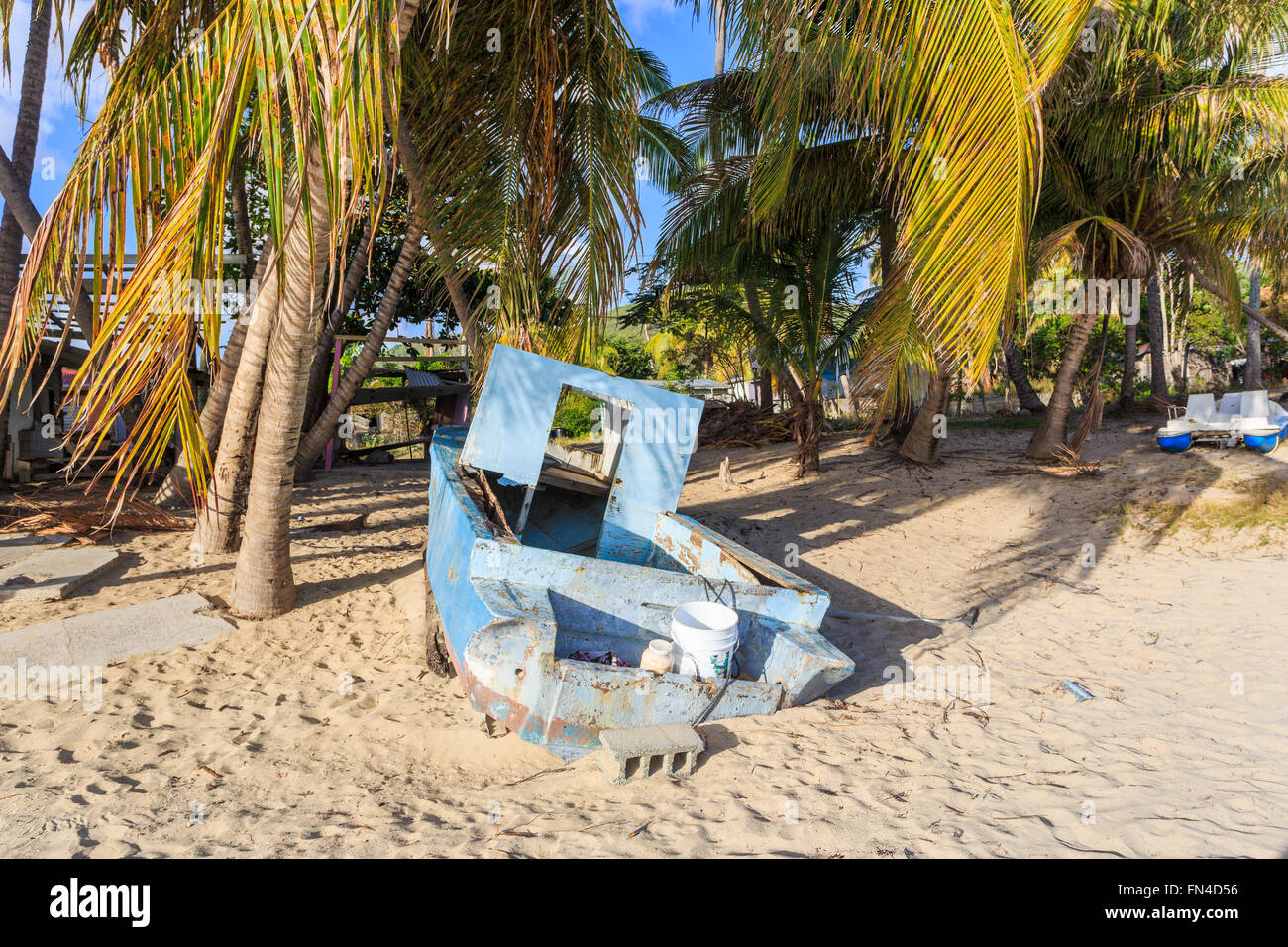 Verfallene blau Holzboot am Strand unter Palmen am Carlisle Bay, Süd-West Antigua, Antigua und Barbuda, West Indies Stockfoto