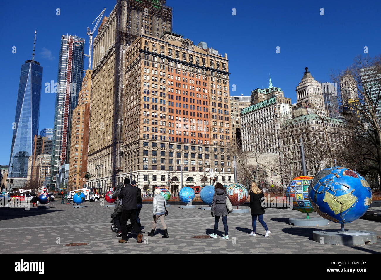 Eine Gruppe von Touristen bewundern die coole Globen-Ausstellung im Battery Park City, New York City, NY, USA Stockfoto